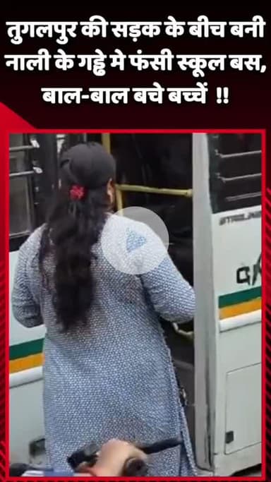 दादरी: तुगलपुर में सड़क के बीच बनी नाली के गड्ढे में फंसी स्कूल बस, बाल-बाल बचे बच्चे