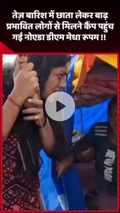 गौतम बुद्ध नगर: तेज़ बारिश में छाता लेकर बाढ़ प्रभावित लोगों से मिलने कैंप पहुंचीं नोएडा की डीएम मेधा रूपम