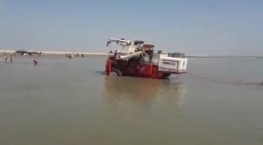 महसी: पचदेवरी गांव के पास गेंहू की कटाई करने जा रही कंबाइन मशीन घाघरा नदी के बीच में फंसी