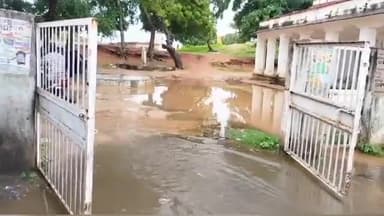 शिवपुरी: दिनारा में रेस्ट हाउस गेट पर पानी की निकासी न होने से ग्रामीण परेशान, गेट पर लटक पार कर रास्ता