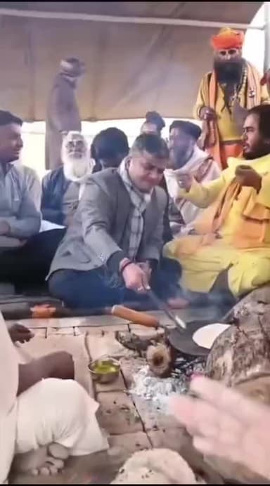 प्रयागराज के डीएम मनीष वर्मा माघ मेला में,साधु-संतों के साथ जमीन पर बैठकर, आत्मीयता से बातचीत के दौरान रोटी पकाते हुए