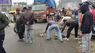चंदौसी: चंदौसी के पथरा तिराही पर मटर के छिलकों से फिसलन होने पर मजदूरों ने सड़क को कराया साफ