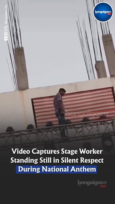 During a large-stage setup with a packed crowd present, a worker paused his task as the National Anthem began to play. S...