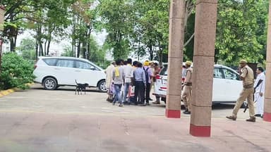 जिलाधिकारी पुलकित गर्ग की सहजता ने जीता जनता का दिल; कलेक्ट्रेट परिसर में गाड़ी रोककर सुनी दूर-दराज से आए ग्रामीणों की पीड़ा
सड़क पर ही लग गई जन अदालत: जब जनता के बीच पहुंचे जिले के मुखिया
यह तस्वीर व्यवस्था के उस मानवीय चेहरे को बयां करती है, जिसे देखने के लिए आम जनता अक्सर तरसती है। जिलाधिकारी पुलकित गर्ग जब अपनी सरकारी गाड़ी में बैठकर किसी प्रशासनिक कार्य के लिए कलेक्ट्रेट से बाहर निकल रहे थे, तभी उनकी नजर वहां खड़े कुछ मायूस और थके हुए ग्रामीणों पर पड़ी। एक आम प्रशासनिक ढर्रे में शायद गाड़ी आगे बढ़ जाती, लेकिन डीएम पुलकित गर्ग ने संवेदनशीलता की मिसाल पेश करते हुए तुरंत अपनी गाड़ी को रुकवा दिया। वे गाड़ी से उतरे और सुरक्षा घेरे को दरकिनार करते हुए सीधे ग्रामीणों के बीच जा पहुंचे। जिलाधिकारी को अपने इतने करीब और इस सहज रूप में देखकर ग्रामीणों की आंखों में उम्मीद की एक नई चमक आ गई।
बौना पुरवा के ग्रामीणों की दर्दभरी दास्तां और 'मसीहा' की भूमिका
ये ग्रामीण कई किलोमीटर का लंबा और थका देने वाला सफर तय करके बौना पुरवा गाँव से आए थे। वे अपने हक और अपनी जमीन से जुड़े चकबंदी के एक पेचीदा मामले को लेकर जिलाधिकारी से गुहार लगाने पहुंचे थे। ग्रामीण इलाकों से आने वाले इन सीधे-साधे लोगों के लिए कलेक्ट्रेट तक का सफर ही किसी चुनौती से कम नहीं होता। बदकिस्मती से, जब तक वे पहुंचे, तब तक काफी विलंब हो चुका था। उन्हें डर था कि अब शायद साहब से मुलाकात नहीं हो पाएगी और उन्हें बिना किसी समाधान के खाली हाथ लौटना पड़ेगा।
लेकिन जिलाधिकारी की सजगता ने उनकी इस चिंता को पल भर में दूर कर दिया। जैसा कि वीडियो में साफ देखा जा सकता है, डीएम पुलकित गर्ग ने परिसर में ही खड़े होकर बेहद धैर्य और आत्मीयता के साथ ग्रामीणों के कागजात देखे और उनकी एक-एक बात को सुना। उन्होंने न सिर्फ उनकी समस्या को समझा, बल्कि उन्हें त्वरित और न्यायसंगत कार्रवाई का पूर्ण आश्वासन भी दिया।
क्यों हो रही है इस 'सरलता' की चौतरफा तारीफ?
एक ग्रामीण के लिए जिला मुख्यालय आना सिर्फ समय का नुकसान नहीं होता, बल्कि उनकी गाढ़ी कमाई का एक बड़ा हिस्सा भी इसमें खर्च हो जाता है। अगर उस दिन डीएम साहब गाड़ी न रोकते, तो इन ग्रामीणों का पूरा दिन, उम्मीदें और मेहनत की कमाई, सब कुछ मिट्टी में मिल जाता।
"प्रशासन जब शासक नहीं, सेवक की भूमिका में आता है, तो जनता का लोकतंत्र पर भरोसा और गहरा हो जाता है।"
जिलाधिकारी पुलकित गर्ग की इस सरलता और संवेदनशीलता ने न केवल उन ग्रामीणों का दिन और पैसा खराब होने से बचा लिया, बल्कि उनका दिल भी जीत लिया। सोशल मीडिया से लेकर आम गलियारों तक, जिले के मुखिया के इस जमीनी और आत्मीय व्यवहार की जमकर सराहना हो रही है। लोग कह रहे हैं कि काश, हर अधिकारी के भीतर जनता के प्रति ऐसी ही सहहानुभूति और कर्तव्यबोध हो।
#dmchitrakoot
#ias
#pulkitgarg
#Chitrakoot