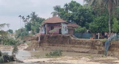 কয়েক ঘণ্টায় ৫০ বাড়ি গঙ্গায়, রতুয়ায় ভাঙনের আতঙ্ক,ভাঙন আতঙ্কে ঘরছাড়া বহু পরিবার, ঘটনাস্থলে প্রশাসন ও বিপর্যয় মোকাবিলা বাহিনী
Bengal icon news মালদহ :মালদার রতুয়া-১ নম্বর ব্লকের মহানন্দটোলা এলাকায় আচমকা শুরু হয়েছে ভয়াবহ গঙ্গাভাঙন। মাত্র কয়েক ঘণ্টার তীব্র ভাঙনে মহানন্দটোলা গ্রাম পঞ্চায়েতের জিতুটোলা গ্রামের প্রায় ৪০ থেকে ৫০টি বসতবাড়ি গঙ্গার গ্রাসে চলে গিয়েছে বলে স্থানীয়দের দাবি। চোখের সামনে ঘরবাড়ি, আসবাবপত্র ও সর্বস্ব নদীগর্ভে তলিয়ে যাওয়ায় কার্যত সর্বহারা বহু পরিবার। ভাঙনের আতঙ্কে ইতিমধ্যেই বহু বাসিন্দা ঘরছাড়া হয়ে নিরাপদ আশ্রয়ের সন্ধানে ছুটছেন।স্থানীয় সূত্রে জানা গিয়েছে, গত কয়েক দিন ধরে মালদায় গঙ্গার জলস্তর কমছিল। রবিবার সকালে জিতুটোলা এলাকায় আচমকাই নদীর পাড়ে ফাটল দেখা দিতে শুরু করে। কিছুক্ষণের মধ্যেই সেই ফাটল ক্রমশ বড় আকার ধারণ করে এবং একের পর এক বসতবাড়ি নদীর দিকে ধসে পড়তে থাকে। পরিস্থিতি এতটাই দ্রুত বদলাতে থাকে যে, অনেক পরিবার ঘর থেকে প্রয়োজনীয় সামগ্রী বের করারও যথেষ্ট সময় পাননি।ভাঙনের তীব্রতা দেখে আতঙ্ক ছড়িয়ে পড়ে গোটা এলাকায়। পরিবারের সদস্যদের নিরাপদে সরিয়ে নেওয়ার পাশাপাশি বাসিন্দারা ঘরের আসবাবপত্র, নথিপত্র এবং অন্যান্য প্রয়োজনীয় জিনিসপত্র নিরাপদ জায়গায় সরিয়ে নেওয়ার চেষ্টা করেন। চোখের সামনে বছরের পর বছর ধরে তৈরি করা বসতবাড়ি নদীগর্ভে তলিয়ে যেতে দেখে কান্নায় ভেঙে পড়েন বহু মানুষ।ভাঙনের খবর পেয়ে ঘটনাস্থলে পৌঁছায় ব্লক প্রশাসন ও পুলিশ। পরিস্থিতি খতিয়ে দেখার পাশাপাশি ঝুঁকিপূর্ণ এলাকা থেকে বাসিন্দাদের নিরাপদ স্থানে সরিয়ে নেওয়ার উদ্যোগ শুরু হয়। ঘটনাস্থলে পৌঁছেছে বিপর্যয় মোকাবিলা বাহিনীও। তাঁরা ভাঙনপ্রবণ এলাকা থেকে বাসিন্দাদের নিরাপদ আশ্রয়ে সরিয়ে নিয়ে যাওয়ার কাজ করছেন।
স্থানীয় বাসিন্দাদের অভিযোগ, গঙ্গার জল কমার সঙ্গে সঙ্গেই আচমকা ভাঙন শুরু হয়েছে। নদীভাঙনের আশঙ্কা আগে থেকেই থাকলেও এত দ্রুত গতিতে ভাঙন তাঁরা আগে দেখেননি। তাঁদের দাবি, কয়েক ঘণ্টার মধ্যেই বহু পরিবার ঘরবাড়ি হারিয়েছে। এখনও ভাঙন অব্যাহত থাকায় নতুন করে আরও বাড়িঘর নদীগর্ভে চলে যাওয়ার আশঙ্কা করছেন তাঁরা।ভাঙন দুর্গতদের অভিযোগ, দীর্ঘদিন ধরে নদীভাঙনের সমস্যা থাকলেও স্থায়ী প্রতিরোধের ব্যবস্থা না হওয়ায় বারবার বিপদের মুখে পড়তে হচ্ছে তাঁদের। আচমকা বসতবাড়ি হারিয়ে সরকারি সাহায্যের আশায় দিন কাটছে বহু পরিবারের। সরকারি উদাসীনতার অভিযোগ তুলে ক্ষোভও উগরে দিয়েছেন দুর্গতরা।প্রশাসনের পক্ষ থেকে পরিস্থিতির উপর নজর রাখা হচ্ছে। দুর্গত পরিবারগুলিকে নিরাপদ আশ্রয়ে সরিয়ে নেওয়ার পাশাপাশি প্রয়োজনীয় ত্রাণ ও সরকারি সহায়তার ব্যবস্থা করার উদ্যোগ নেওয়া হয়েছে। তবে ভাঙন পুরোপুরি না থামলে নতুন করে কতগুলি পরিবার ক্ষতিগ্রস্ত হবে, তা নিয়ে উদ্বেগ বাড়ছে। অনিশ্চিত ভবিষ্যতের মুখে দাঁড়িয়ে এখন জিতুটোলা গ্রামের বহু পরিবার।