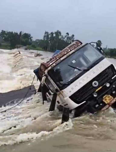 ফের ভেসে গেল বাঁকুড়ার গন্ধেশ্বরী নদীর মানকানালী সেতু। ভেসে যাওয়া সেতু দিয়ে পারাপার করতে গিয়ে দুর্ঘটনার কবলে পড়লো একটি ডাম্পার।
নিম্ন চাপের জেরে গতকাল থেকে ভারী বৃষ্টি শুরু হয়েছে বাঁকুড়া জেলায়। এর ফলে বাঁকুড়ার উপর দিয়ে বয়ে যাওয়া গন্ধেশ্বরী দ্বারকেশ্বর সহ সব নদীতেই জলস্তর বৃদ্ধি পেয়েছে। জলস্তর বৃদ্ধি পাওয়ায় গতকাল থেকেই ডুবে রয়েছে গন্ধেশ্বরী নদীর উপর থাকা বাঁকুড়ার মানকানালী সেতু। আজ ভোরে ডুবে থাকা সেই সেতু ঝুঁকি নিয়ে পারাপার করতে গিয়ে সেতুর মাঝখানে আটকে যায় একটি ডাম্পার। কোনোক্রমে চালক খালাসি প্রাণে বাঁচলেও ডাম্পার উদ্ধার করা যায়নি। লাগাতার ভারী বৃষ্টি হতে থাকায় গন্ধেশ্বরীর জলস্তর আরো বৃদ্ধি পাচ্ছে। সে ক্ষেত্রে পরিস্থিতি যে আরও খারাপ হবে তা বলার অপেক্ষা রাখে না