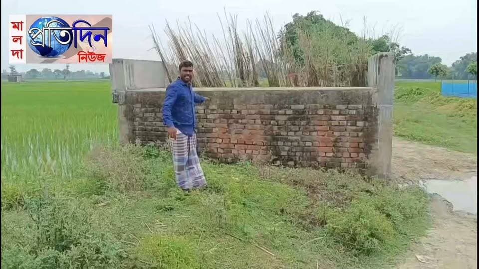 সুশান্ত সরকার মালদাঃ কালভার্ট তৈরি, সংযোগপথ উধাও, দুর্ভোগে কুশলপুর
হরিশ্চন্দ্রপুর : এলাকার যোগাযোগ ব্যবস্থা উন্নত করতে প্রায় ২ লক্ষ টাকা ব্যয়ে কালভার্ট নির্মাণ করা হয়েছিল। কিন্তু কালভার্ট তৈরির পরও মেলেনি রাস্তার সঙ্গে সংযোগ। কালভার্টের দু’পাশে মাটি ভরাট না করায় তৈরি হয়েছে গভীর গর্ত। কাদা ও জমা জল পেরিয়ে বিপজ্জনকভাবে যাতায়াত করতে হচ্ছে বাসিন্দাদের। ফলে সরকারি অর্থে নির্মিত কালভার্ট কার্যত অব্যবহারের মুখে। ঘটনাটি হরিশ্চন্দ্রপুর-১ ব্লকের কুশলপুর গ্রামের। স্থানীয় সূত্রে জানা গিয়েছে, প্রায় বছরখানেক আগে হরিশ্চন্দ্রপুর গ্রাম পঞ্চায়েতের উদ্যোগে কালভার্টটি নির্মাণ করা হয়। অভিযোগ, নির্মাণের পর কালভার্টের দু’পাশে প্রয়োজনীয় মাটি ফেলে রাস্তার সঙ্গে সমতল করা হয়নি। রাস্তার তুলনায় কালভার্টটি উঁচু হওয়ায় দুই প্রান্তে তৈরি হয়েছে বড় গর্ত। সামান্য বৃষ্টি হলেই সেখানে জল-কাদা জমে পরিস্থিতি আরও ভয়াবহ হয়ে ওঠে।
স্থানীয়দের অভিযোগ, কালভার্ট তৈরি হলেও সংযোগপথের কাজ অসম্পূর্ণ রেখে দেওয়ায় সাইকেল, মোটরবাইক তো দূরের কথা, সাধারণ পথচারীদেরও চলাচলে চরম সমস্যায় পড়তে হচ্ছে। বাধ্য হয়ে কালভার্ট এড়িয়ে জলাশয়ের ধার দিয়ে ঘুরপথে যাতায়াত করছেন তাঁরা। বাসিন্দা এনামুল হক ও রফিকুল ইসলামের দাবি, এই রাস্তা দিয়ে তিন-চারটি গ্রামের মানুষ নিয়মিত যাতায়াত করেন। কবরস্থান ও শ্মশানে মৃতদেহ নিয়ে যাওয়া থেকে শুরু করে মাঠের ফসল আনা-নেওয়া—সব ক্ষেত্রেই রাস্তাটি অত্যন্ত গুরুত্বপূর্ণ। অথচ কালভার্ট নির্মাণের পরও সংযোগপথ তৈরি না হওয়ায় সাধারণ মানুষের দুর্ভোগ কমার বদলে বেড়েছে।
বাসিন্দাদের প্রশ্ন, কালভার্ট নির্মাণের পর রাস্তার সঙ্গে সংযোগ তৈরি করা হল না কেন? প্রায় এক বছর ধরে কেনই বা পড়ে রয়েছে এই অসম্পূর্ণ কাজ? সরকারি অর্থ খরচ করে এমন পরিকাঠামো তৈরি করে তা ব্যবহারযোগ্য না করে রাখার যৌক্তিকতা নিয়েও প্রশ্ন তুলেছেন তাঁরা। দ্রুত কালভার্টের দু’পাশে মাটি ভরাট করে রাস্তার সঙ্গে সমতল সংযোগ তৈরি এবং কাঁচা অংশ পাকা করার দাবি জানিয়েছেন স্থানীয়রা। তাঁদের বক্তব্য, শুধু কালভার্ট বানালেই হবে না, সেটিকে মানুষের ব্যবহারের উপযোগী করাও প্রশাসনের দায়িত্ব।