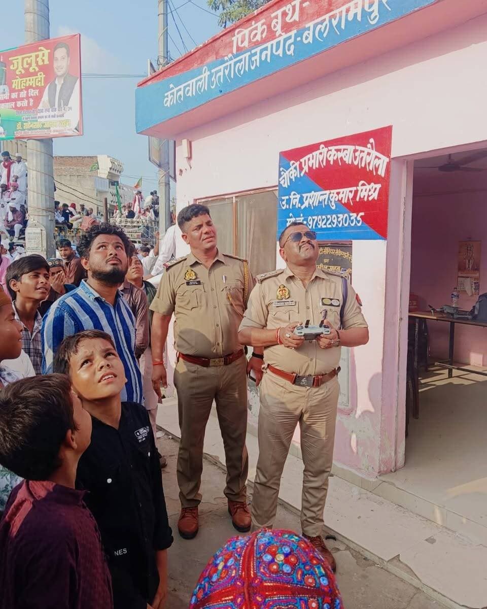 बारह रबीउल अव्वल पर उतरौला में रही पुलिस की पैनी नजर: एएसपी ने ड्रोन से परखी सुरक्षा, जुलूस मार्ग का लिया जायजा
बलरामपुर। (ईद-ए-मिलाद-उन-नबी) को शांतिपूर्ण, सुरक्षित और सौहार्दपूर्ण वातावरण में संपन्न कराने के लिए जनपद पुलिस ने कमर कस ली है। पुलिस अधीक्षक मार्तण्ड प्रकाश सिंह के निर्देशन में बुधवार को अपर पुलिस अधीक्षक विशाल पाण्डेय ने उतरौला कस्बे का सघन भ्रमण कर सुरक्षा व्यवस्था का जायजा लिया।
त्यौहार के दृष्टिगत एएसपी ने जुलूस मार्ग, संवेदनशीलता वाले इलाकों, मुख्य चौराहों और छतों की सुरक्षा जांचने के लिए स्वयं ड्रोन कैमरे से हवाई निगरानी की। इस दौरान छतों पर पत्थरों की स्थिति, गलियों में संदिग्ध गतिविधियों और यातायात प्रबंधन को ड्रोन के जरिए परखा गया। साथ ही, जुलूस मार्ग पर स्थापित सीसीटीवी कैमरों, बैरियरों और ड्यूटी पर तैनात पुलिस पिकेट की कार्यप्रणाली को भी री-चेक किया गया।
एएसपी विशाल पाण्डेय ने मातहतों को मुस्तैदी बरतने और गश्त बढ़ाने के सख्त निर्देश दिए। बलरामपुर पुलिस ने आम नागरिकों से अपील की है कि वे त्यौहार को आपसी भाईचारे और सौहार्द के साथ मनाएं। किसी भी अफवाह या संदिग्ध गतिविधि की सूचना तत्काल आपातकालीन नंबर डायल 112 या स्थानीय थाने को दें।