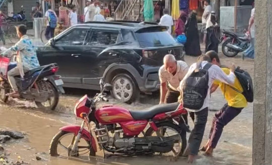 किंजर कुर्था मोड़ पर जलजमाव से राहत नहीं, खोदे गए गड्ढे बने नई मुसीबत
अरवल-जहानाबाद को जोड़ने वाले एनएच-33 पर किंजर-कुर्था मोड़ के समीप जलजमाव की समस्या लगातार गंभीर होती जा रही है। कई दिनों से सड़क पर जमा बारिश का पानी अब बड़े जलाशय का रूप ले चुका है। मुख्य सड़क पर करीब दो फीट तक गंदा पानी जमा रहने से राहगीरों और वाहन चालकों को काफी परेशानी हो रही है।
जल निकासी के उद्देश्य से करीब 20 दिन पूर्व एनएच-33 के दक्षिणी किनारे जिला प्रशासन के निर्देश पर जेसीबी से गड्ढा खोदा गया था। हालांकि, इससे जलजमाव की समस्या दूर नहीं हुई। उल्टे खोदे गए गड्ढे में पानी भर जाने से यह राहगीरों और बाइक सवारों के लिए खतरा बन गया है। कई बाइक सवार इसमें गिरकर दुर्घटना का शिकार हो चुके हैं।
किंजर होकर अरवल, करपी और इमामगंज की ओर आने-जाने वाले वाहन चालकों को गंदे पानी से होकर गुजरना पड़ रहा है। स्थानीय लोगों का कहना है कि समस्या के स्थायी समाधान के बजाय एक स्थान पर गड्ढा खोदकर छोड़ दिया गया है, जिससे परेशानी और बढ़ गई है।
बताया जाता है कि करीब 8-10 दिन पूर्व अरवल जिला प्रशासन के निर्देश पर अरवल नगर परिषद की दो सेक्शन मशीनों से किंजर में जमा पानी को निकालकर समीप के पईन में डाला गया था। इससे कुछ समय के लिए सड़क से पानी हट गया था। लेकिन इसके बाद लगातार तीन दिनों से रात में हो रही बारिश के कारण फिर से जलजमाव की स्थिति उत्पन्न हो गई है।
स्थानीय लोगों के अनुसार एनएच-33 के दोनों किनारों पर बने नालों में कचरा जमा है। नालों की सफाई नहीं होने के कारण बारिश का पानी पईन तक नहीं पहुंच पा रहा है। लोगों का कहना है कि पहले नालों के ऊपर लगे स्लैब को हटाकर उसकी पूरी तरह सफाई कराई जाए, तभी जल निकासी की समस्या का स्थायी समाधान संभव है।
ग्रामीणों ने प्रशासन और एनएच-33 के अधिकारियों से सड़क किनारे खोदे गए गड्ढों को तत्काल भरने और नालों की सफाई कराने की मांग की है। उनका कहना है कि जलजमाव के साथ-साथ गड्ढों के कारण दुर्घटना का खतरा लगातार बना हुआ है। समय रहते कार्रवाई नहीं हुई तो किसी बड़े हादसे से इनकार नहीं किया जा सकता।