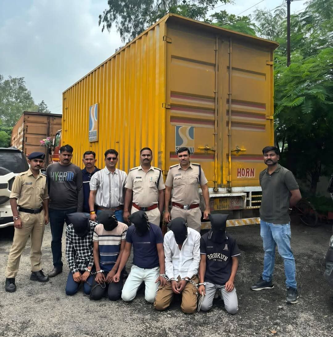 चाकू की नोक पर 9 टन आटे से भरा कंटेनर लूटा, GPS ने खोल दिया डकैती का राज
देवास से इंदौर तक पुलिस ने किया पीछा, सर्विस रोड पर ट्रांसफार्मर से टकराया कंटेनर; 5 आरोपी गिरफ्तार, करीब 50 लाख का माल बरामद
देवास। औद्योगिक क्षेत्र स्थित अवंतिका फूड्स कंपनी से 9 टन आटे से भरे कंटेनर की डकैती का पुलिस ने कुछ ही घंटों में खुलासा कर दिया। बदमाशों ने चालक को चाकू की नोक पर धमकाकर कंटेनर समेत 310 कट्टे आटा लूट लिया था। वारदात के बाद भागे आरोपियों तक पहुंचने में कंटेनर में लगा GPS पुलिस के लिए सबसे बड़ा सुराग बना। GPS लोकेशन, CCTV फुटेज और मुखबिर तंत्र की मदद से देवास पुलिस ने इंदौर तक पीछा किया और पांचों आरोपियों को गिरफ्तार कर लिया। पुलिस ने कंटेनर और उसमें भरा करीब 9 टन आटा समेत लगभग 50 लाख रुपए का मशरूका शत-प्रतिशत बरामद किया है।
चालक को चाकू अड़ाकर नीचे फेंका
घटना 5 सितंबर की रात करीब 8:30 बजे की है। इंदौर की शिवानी ट्रांसपोर्ट का चालक संतोष मालवीय खाली कंटेनर लेकर देवास की राजीव नगर भट्टा स्थित अवंतिका फूड्स कंपनी पहुंचा था। कंपनी ने कंटेनर में आर्शीवाद कंपनी के आटे के 310 कट्टे, कुल करीब 9 टन माल लोड किया।
कंटेनर लेकर निकलने की तैयारी के दौरान एक बदमाश ड्राइवर साइड से पहुंचा और चालक की कमर पर चाकू अड़ाकर जान से मारने की धमकी दी। इसके बाद कॉलर पकड़कर उसे नीचे फेंक दिया। घटना में चालक के हाथ और घुटनों में चोट आई। इसी दौरान चार अन्य बदमाश कंडक्टर साइड से कंटेनर में चढ़ गए और आटे से भरा कंटेनर लेकर फरार हो गए। बदमाशों ने कंपनी के गार्ड को भी धमकाया और भागते समय कंपनी का गेट भी क्षतिग्रस्त कर दिया।
हालांकि चाकू दिखाने वाला एक आरोपी मौके पर ही रह गया, जिसे चालक और कंपनी के गार्डों की मदद से पकड़ लिया गया। घटना की सूचना तत्काल डायल-112 पर दी गई। पुलिस के मुताबिक सूचना मिलते ही करीब पांच मिनट में पुलिस सक्रिय हो गई।
GPS की लोकेशन ने बदमाशों की राह दिखाई
मामले की गंभीरता को देखते हुए पुलिस ने तत्काल विशेष टीम गठित की। पूछताछ और तकनीकी जानकारी में पता चला कि लूटे गए कंटेनर में GPS डिवाइस लगा है। इसकी लोकेशन इंदौर की ओर बढ़ रही थी। इसके बाद देवास पुलिस ने GPS लोकेशन के साथ CCTV फुटेज और मुखबिर तंत्र को जोड़कर कंटेनर का पीछा शुरू किया।
इंदौर कंट्रोल रूम, तेजाजी नगर और राऊ थाना पुलिस को भी सूचना देकर नाकाबंदी कराई गई। देवास और इंदौर पुलिस के समन्वित प्रयास से कंटेनर की घेराबंदी की गई।
पुलिस को देखकर सर्विस रोड पर उतारा कंटेनर
पुलिस की नाकाबंदी देखकर आरोपी कंटेनर को मुख्य मार्ग से नीचे सर्विस रोड पर ले गए। इसी दौरान कंटेनर अनियंत्रित होकर एक ट्रांसफार्मर से जा टकराया। पुलिस टीम ने मौके पर पहुंचकर कंटेनर में बैठे सूरज बैरागी (19) को हिरासत में ले लिया।
पूछताछ में सूरज ने अपने चार साथियों के साथ मिलकर अवंतिका फूड्स से चालक को चाकू की नोक पर धमकाकर कंटेनर और उसमें भरे आटे की डकैती करना स्वीकार किया। इसके बाद पुलिस ने त्वरित कार्रवाई करते हुए बाकी चार आरोपियों को भी गिरफ्तार कर लिया।
पांचों आरोपी गिरफ्तार, चाकू भी बरामद
पुलिस ने आरोपियों की निशानदेही पर वारदात में इस्तेमाल किया गया धारदार चाकू भी बरामद किया है। मामले में आयुध अधिनियम की धारा 25 भी जोड़ी गई है।
गिरफ्तार आरोपियों की पहचान सुनील चौहान (35), शुभम राजौरिया (19), आकाश बैरागी (20), भावेश पटेल (18) और सूरज बैरागी (19), सभी निवासी देवास के रूप में हुई है।
पुलिस ने कंटेनर MP09AZ1441, उसमें भरा 9 टन आर्शीवाद कंपनी का आटा और वारदात में प्रयुक्त चाकू बरामद किया है। बरामद मशरूका की कुल कीमत करीब 50 लाख रुपए बताई गई है।
पुराने अपराध भी दर्ज
पुलिस के अनुसार आरोपी सुनील चौहान के खिलाफ औद्योगिक क्षेत्र थाने में वर्ष 2011 से लेकर 2026 तक मारपीट, धमकी, चोरी और अन्य धाराओं में कई प्रकरण दर्ज हैं। वहीं आरोपी सूरज बैरागी के खिलाफ भी औद्योगिक क्षेत्र थाने में एक मामला दर्ज है।
पुलिस ने इस पूरी कार्रवाई को तकनीकी साक्ष्यों, त्वरित सूचना तंत्र और देवास-इंदौर पुलिस के बीच बेहतर समन्वय का परिणाम बताया है। विशेष रूप से वारदात के तुरंत बाद डायल-112 पर मिली सूचना और कंटेनर के GPS ने जांच को दिशा देने में अहम भूमिका निभाई।