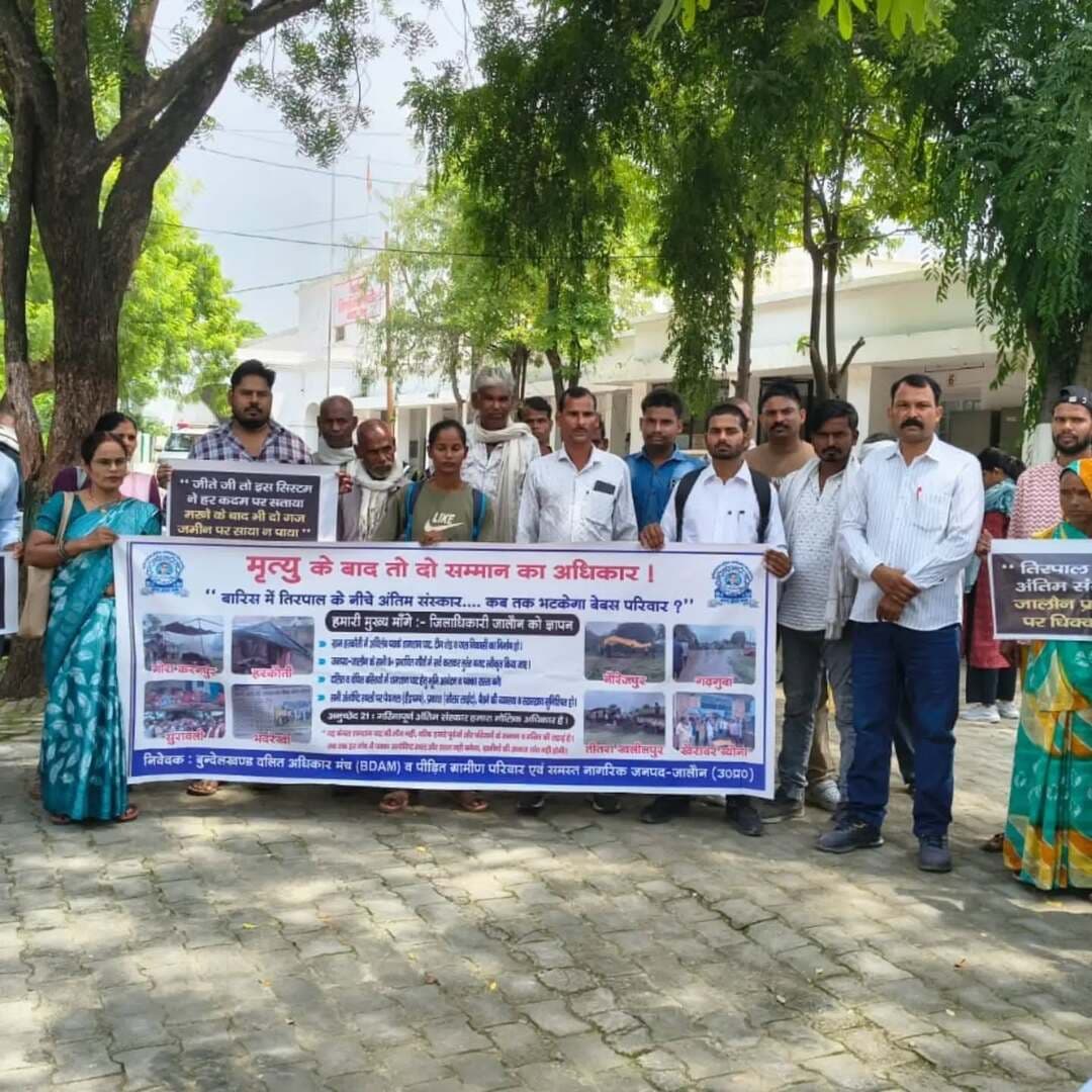 बारिश में तिरपाल के नीचे अंतिम संस्कार को मजबूर ग्रामीण
अंत्येष्टि स्थलों की बदहाली को लेकर डीएम को ज्ञापन, पक्के शेड व पहुंच मार्ग की मांग
उरई (जालौन)। जिले के ग्रामीण क्षेत्रों में अंत्येष्टि स्थलों की बदहाली को लेकर बुंदेलखंड दलित अधिकार मंच ने जिलाधिकारी को ज्ञापन सौंपकर व्यवस्थाएं दुरुस्त कराने की मांग की है। मंच का आरोप है कि कई गांवों में पक्के श्मशान घाट, टीन शेड और पहुंच मार्ग नहीं होने से बारिश के दौरान ग्रामीणों को तिरपाल के नीचे अंतिम संस्कार करना पड़ता है।
मंच के अनुसार, बीते एक माह में हरकौती, भदरेखी, नौरेजपुर, सुरावली, गोराकरनपुर, गढ़गुवा, तीतराखलीलपुर, खैरवार व्योना और हैदलपुर समेत नौ से अधिक गांवों में ऐसी समस्याएं सामने आई हैं। हरकौती में देवेंद्र दोहरे के निधन के बाद बारिश के बीच अंतिम संस्कार के लिए परिजनों को काफी परेशानी उठानी पड़ी।
मंच के संयोजक एवं हाईकोर्ट अधिवक्ता कुलदीप कुमार बौद्ध ने कहा कि मृत्यु के बाद भी व्यक्ति को गरिमापूर्ण अंतिम संस्कार का अधिकार है। उन्होंने अंत्येष्टि स्थलों की बदहाली को गंभीर मानवीय और संवैधानिक मुद्दा बताया।
ज्ञापन में प्रभावित गांवों में पक्के टीन शेड, ऊंचे चबूतरे, पेयजल, जल निकासी, सोलर लाइट और सीसी मार्ग बनाने के साथ ही जरूरत वाले गांवों में श्मशान के लिए भूमि उपलब्ध कराने की मांग की गई। मानसून तक अस्थायी शेड और तिरपाल की व्यवस्था कराने की भी मांग उठाई गई। मंच ने संबंधित अधिकारियों की जवाबदेही तय करने की मांग की है।
ज्ञापन देने वालों में उरई तहसील संयोजक प्रदीप कुमार, माधौगढ़ के सचिन कुमार, कोच के धीरज-स्नेहराजा, जालौन की उषा देवी-देवेंद्र अनिल, कालपी की अनीता देवी-सुरेंद्र कुमार, हैदलपुर के दीपक वर्मा, वर्षा देवी, हरकौती के ग्राम प्रधान मुहम्मद अनीश सहित विभिन्न गांवों के प्रतिनिधि और ग्रामीण मौजूद रहे।