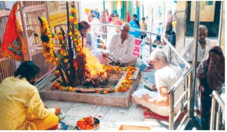 तिलस्वां महादेव की एक झलक को घंटों इंतजार, उमड़ा श्रद्धालुओं का सैलाब
भीलवाड़ा (रमेश चंद्र डाड)। भाद्रपद अमावस्या के पावन अवसर पर प्रसिद्ध तिलस्वां महादेव मंदिर आस्था और भक्ति का केंद्र बना रहा। अलसुबह से ही दूर-दराज के क्षेत्रों और आसपास के गांवों से श्रद्धालुओं के पहुंचने का सिलसिला शुरू हो गया। देखते ही देखते मंदिर परिसर और आसपास का क्षेत्र श्रद्धालुओं की भीड़ से भर गया। भगवान शिव की एक झलक पाने के लिए भक्तों को कतारों में लगकर घंटों अपनी बारी का इंतजार करना पड़ा।
मंदिर परिसर में दिनभर ‘हर-हर महादेव’ और ‘बम-बम भोले’ के जयकारे गूंजते रहे। कतार में खड़े श्रद्धालु शिव नाम का स्मरण करते हुए अपनी बारी का इंतजार करते नजर आए। दर्शन के बाद श्रद्धालुओं ने भगवान शिव का पूजन-अभिषेक कर सुख-समृद्धि और परिवार की खुशहाली की कामना की।
वैदिक मंत्रोच्चार के बीच विशेष अनुष्ठान
तिलस्वां महादेव मंदिर ट्रस्ट की ओर से विशेष धार्मिक अनुष्ठान आयोजित किए गए। विद्वान आचार्यों ने वैदिक मंत्रोच्चार के बीच भगवान शिव का विशेष जलाभिषेक कराया। इसके साथ ही हवन एवं विशेष पूजा-अर्चना संपन्न हुई। श्रद्धालुओं ने ललाट पर केसर का तिलक धारण कर शिव नाम का स्मरण किया और भगवान महादेव के दर्शन कर पुण्य लाभ अर्जित किया।
दर्शन व्यवस्था को लेकर ट्रस्ट ने संभाला मोर्चा
तिलस्वां महादेव मंदिर ट्रस्ट के अध्यक्ष रमेश चन्द अहीर एवं सचिव मांगीलाल धाकड़ ने बताया कि भाद्रपद अमावस्या का क्षेत्र में विशेष धार्मिक महत्व है। इसी आस्था के चलते आसपास के गांवों के साथ-साथ दूर-दराज के क्षेत्रों से भी बड़ी संख्या में श्रद्धालु मंदिर पहुंचे।
श्रद्धालुओं की भारी भीड़ को देखते हुए मंदिर ट्रस्ट की ओर से सुगम दर्शन, कतार प्रबंधन और सुरक्षा के विशेष इंतजाम किए गए। व्यवस्थाओं के चलते श्रद्धालुओं को निर्धारित कतारों के माध्यम से मंदिर में प्रवेश कराया गया और दर्शन के बाद निकासी की व्यवस्था भी सुचारु रखी गई।
भाद्रपद अमावस्या पर दिनभर चले धार्मिक आयोजनों और श्रद्धालुओं की मौजूदगी से तिलस्वां महादेव मंदिर परिसर पूरी तरह शिवमय नजर आया। आस्था का ऐसा सैलाब उमड़ा कि महादेव के दर्शन के लिए भक्तों में घंटों इंतजार करने के बावजूद उत्साह और श्रद्धा कम नहीं हुई।