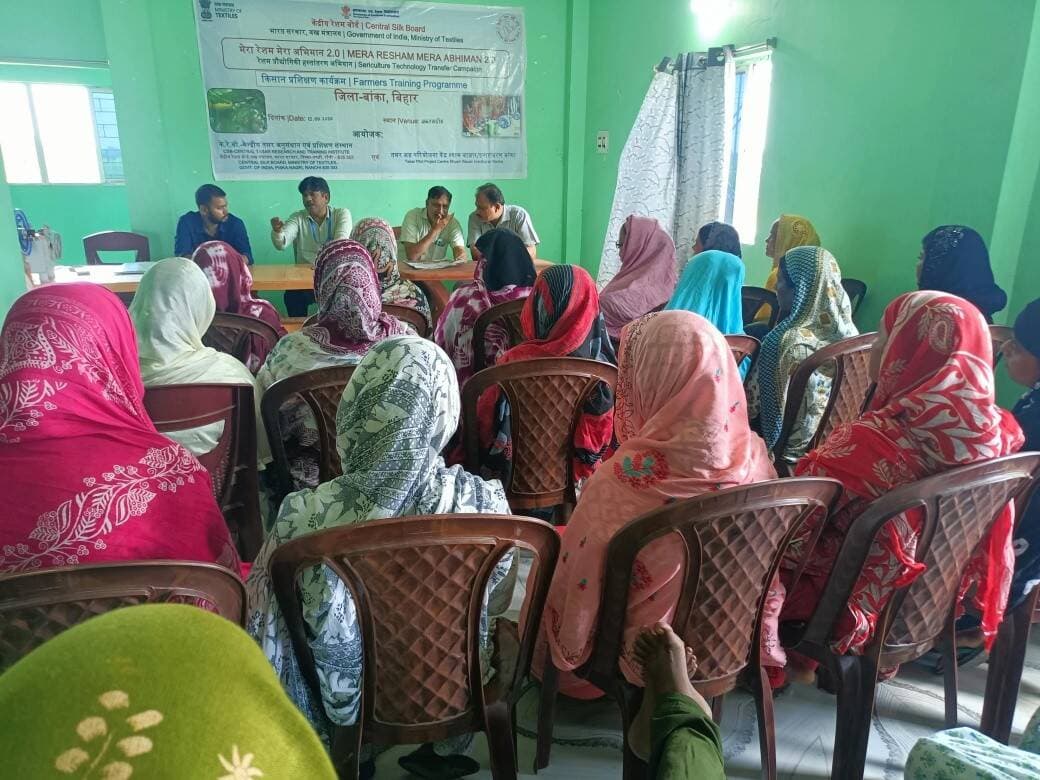 बेहतर उत्पादकता हेतु वैज्ञानिक रीलिंग तकनीकों पर कृषक प्रशिक्षण कार्यक्रम का आयोजन
केंद्रीय रेशम बोर्ड, सीएसबी-सीटीआरटीआई, रांची एवं तसर अग्र परियोजना केंद्र इनारावरण द्वारा “मेरा रेशम मेरा अभिमान (MRMA) 2.0” के अंतर्गत दिनांक 12.09.2026 को मकरमाडीह, प्रखंड राजौन, जिला बांका, बिहार में “Better Techniques for Higher Productivity During Reeling” विषय पर रीलरों के लिए किसान प्रशिक्षण कार्यक्रम का आयोजन किया गया।
कार्यक्रम के मुख्य अतिथि श्री के.के. भारती, महाप्रबंधक, जिला उद्योग केंद्र (DIC), बांका ने रीलरों से संवाद किया तथा रीलिंग गतिविधियों को अधिक प्रभावी ढंग से संचालित करने के लिए आवश्यक कार्यशील पूंजी (Working Capital) की समस्या पर चर्चा की। रीलरों की मांग के संदर्भ में उन्होंने बैंकों द्वारा उपलब्ध विभिन्न प्रकार के ऋण एवं वित्तीय सहायता की जानकारी दी तथा इन सुविधाओं का लाभ उठाकर अपने कार्य को बढ़ाने के लिए प्रेरित किया। उन्होंने रीलरों को रीलिंग क्षेत्र में उपलब्ध नवीनतम तकनीकों के प्रति जागरूक रहने तथा आधुनिक तकनीकों को अपनाने पर जोर दिया।
श्री आशु कुमार, वैज्ञानिक-बी, सीएसबी-सीटीआरटीआई, रांची एवं नोडल अधिकारी, MRMA 2.0, बांका ने रीलरों के साथ संवाद कर रीलिंग गतिविधियों में आने वाली प्रमुख समस्याओं पर चर्चा की। रीलरों ने बताया कि कुछ खरीदार मशीन से निर्मित धागे की अपेक्षा थाई-रील्ड (Thigh-reeled) यार्न की मांग करते हैं, जिसके कारण मशीन रीलिंग को अपनाने में उन्हें कठिनाई होती है।
इस पर श्री आशु कुमार ने सुझाव दिया कि रीलरों को ऐसे बाजार एवं खरीदारों से जुड़ना चाहिए जहां मशीन-रील्ड तसर यार्न की अच्छी मांग उपलब्ध है। उन्होंने देश के अन्य प्रमुख तसर उत्पादक राज्यों में अपनाई जा रही तकनीकों एवं प्रक्रियाओं का उदाहरण देते हुए बताया कि उपयुक्त रीलिंग एवं फिनिशिंग तकनीकों के माध्यम से मशीन से तैयार यार्न में थाई-रील्ड यार्न जैसी बनावट एवं विशेषताओं को विकसित किया जा सकता है। इससे मशीन रीलिंग को बढ़ावा देने के साथ-साथ उत्पादकता, गुणवत्ता और रीलरों की आय में वृद्धि की संभावना है।
कार्यक्रम के दौरान रीलरों ने अपनी तकनीकी एवं व्यावसायिक समस्याएं साझा कीं तथा विशेषज्ञों से उनके समाधान के संबंध में जानकारी प्राप्त की। कार्यक्रम का उद्देश्य रीलरों को उन्नत रीलिंग तकनीकों से अवगत कराना, उत्पादकता एवं यार्न गुणवत्ता में सुधार करना तथा तसर रीलिंग को अधिक लाभकारी एवं बाजारोन्मुख बनाना रहा।
