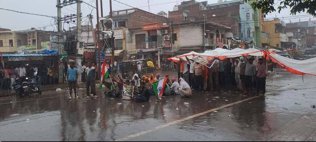 रामगढ़ में जवान की मौत पर धरना जारी, DM-SP को बुलाने की जिद पर अड़े ग्रामीण, बारिश में भी रोड जाम
कैमूर / रामगढ़ आर्मी जवान शत्रुघ्न यादव की मौत के बाद रामगढ़ में आक्रोश थमने का नाम नहीं ले रहा है। परिजन और ग्रामीण DM-SP को मौके पर बुलाने की जिद पर अड़े हैं।
आक्रोशित लोगों ने दुर्गा चौक पर NH-319A पर टेंट लगाकर सड़क जाम कर दिया है। भारी बारिश के बावजूद ग्रामीण सड़क पर डटे हुए हैं और लगातार नारेबाजी कर रहे हैं।
ग्रामीणों की मांग है कि जब तक DM-SP मौके पर नहीं आएंगे और फरार आरोपी की गिरफ्तारी नहीं होगी, तब तक जाम नहीं हटेगा।
स्थिति को नियंत्रित करने के लिए SDM रत्ना प्रियदर्शी और DSP समेत भारी पुलिस बल मौके पर मौजूद है और ग्रामीणों को समझाने-बुझाने में जुटे हैं, लेकिन ग्रामीण मानने को तैयार नहीं हैं।