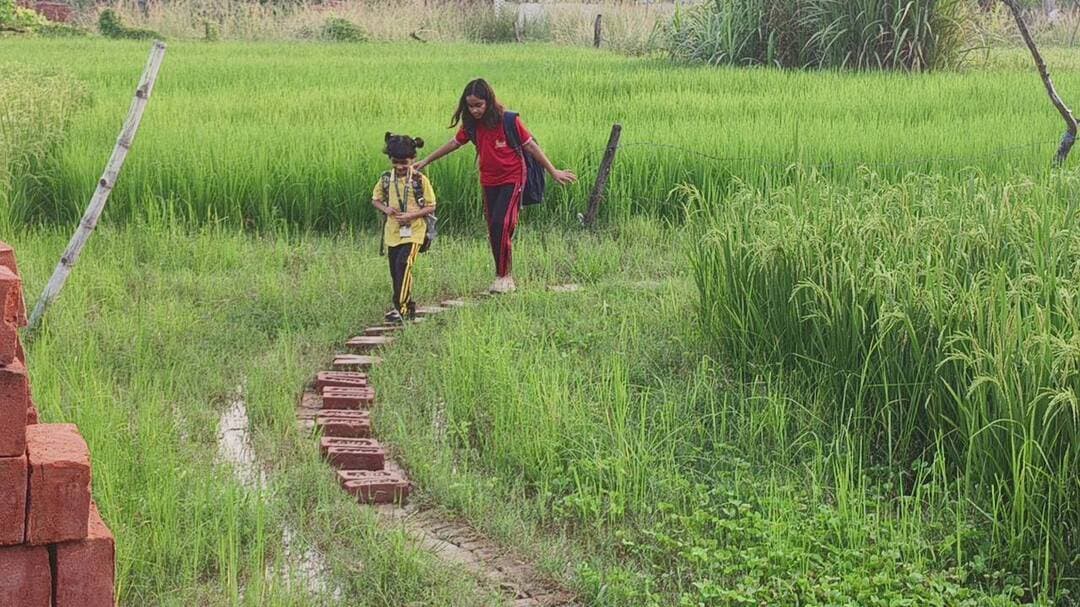 डीएम साहब! हमारी भी सुन लीजिए गुहार...
#Mau #MauNews
सीआरपीएफ जवान की बेटियों ने वीडियो बनाकर मांगा स्कूल जाने का रास्ता, बारिश में कीचड़ और जलभराव से परेशान हैं काव्या और तृषा
मामला मऊ नगर पालिका परिषद के वार्ड नंबर सात स्थित विवेकानंद कॉलोनी का है, जो परदहा मिल क्षेत्र में पड़ता है। यहां रहने वाले अमित सिंह छत्तीसगढ़ के सुकमा में सीआरपीएफ में तैनात हैं। उनकी आठ वर्षीय बेटी काव्या कक्षा तीन में, जबकि छोटी बेटी तृषा नर्सरी में पढ़ती है।
बच्चियों के मुताबिक, पिता ड्यूटी के कारण घर से दूर रहते हैं। ऐसे में वह उन्हें रोज स्कूल छोड़ने और लेने नहीं आ सकते। बारिश के दिनों में घर के पास रास्ते पर पानी और कीचड़ भर जाने से स्कूल पहुंचना उनके लिए मुश्किल हो जाता है।