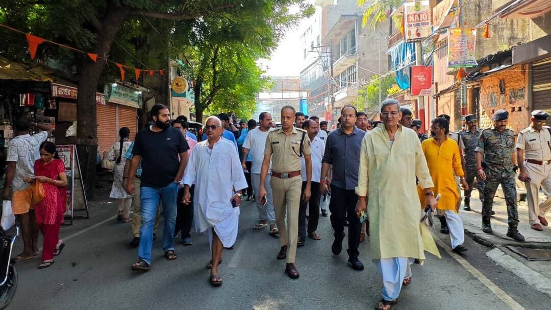 पितृपक्ष मेला से पहले अंदर गया की गलियों में उतरे, डीएम-एसएसपी: गड्ढे, नाली और लटकते बिजली तारों पर सख्ती; 24 घंटे एक्टिव रहेगा कंट्रोल रूम
धावा दल करेगा मेला क्षेत्र का औचक निरीक्षण, बार-बार आने वाली शिकायतों की बनेगी अलग सूची; डीएम ने अधिकारियों को सेवा भाव से काम करने का दिया निर्देश
गया: पितृपक्ष मेला 2026 में देश-विदेश से गया पहुंचने वाले श्रद्धालुओं की सुविधा, सुरक्षा और सुगम आवागमन को लेकर जिला प्रशासन ने तैयारियों को अंतिम रूप देना शुरू कर दिया है। मंगलवार को जिलाधिकारी डॉ. शशांक शुभंकर और वरीय पुलिस अधीक्षक सुशील कुमार ने पंडा-पुरोहितों, समाजसेवियों, जिला प्रशासन तथा नगर निगम के अधिकारियों के साथ अंदर गया की संकरी गलियों का पैदल निरीक्षण किया। इस दौरान अधिकारियों ने श्रद्धालुओं के पैदल आवागमन वाले रास्तों से लेकर नालियों, बिजली के तारों और प्रकाश व्यवस्था तक का जायजा लिया।
निरीक्षण के दौरान डीएम ने स्पष्ट निर्देश दिया कि पितृपक्ष मेला के दौरान श्रद्धालुओं को किसी भी तरह की परेशानी नहीं होनी चाहिए। अंदर गया की संकरी गलियां भी मेला व्यवस्था का महत्वपूर्ण हिस्सा हैं। इन गलियों में जहां गड्ढे या असमतल रास्ते हैं, वहां तत्काल समतलीकरण कराया जाए। नालियों की सफाई, ढक्कन की व्यवस्था और नियमित सफाई सुनिश्चित करने को कहा गया, ताकि जलजमाव या गंदगी के कारण श्रद्धालुओं को परेशानी न हो।
पंडा-पुरोहितों के आवासन वाले इलाकों पर भी विशेष फोकस
डीएम ने कहा कि पितृपक्ष मेला के दौरान तीर्थयात्री केवल मुख्य सड़कों से ही आवागमन नहीं करते हैं। बड़ी संख्या में श्रद्धालु अंदर गया की संकरी गलियों का इस्तेमाल करते हैं। अधिकांश पंडा-पुरोहितों के निजी आवासन भवन भी इन्हीं क्षेत्रों में स्थित हैं। इसलिए इन इलाकों में सफाई, सड़क, नाली, प्रकाश और अन्य नागरिक सुविधाओं को दुरुस्त रखना जरूरी है।
उन्होंने नगर निगम और संबंधित विभागों के अधिकारियों को निर्देश दिया कि सभी प्रमुख पैदल मार्गों को श्रद्धालुओं के आवागमन के अनुरूप व्यवस्थित रखा जाए। जहां रास्ते टूटे अथवा असमतल हैं, वहां तत्काल काम पूरा कराया जाए।
लटकते और जर्जर तारों को तत्काल हटाने का निर्देश
निरीक्षण के दौरान बिजली व्यवस्था भी डीएम के फोकस में रही। उन्होंने संबंधित अधिकारियों से गलियों में बिजली के तारों की स्थिति की जानकारी ली। निर्देश दिया गया कि बिजली के तार निर्धारित मानकों के अनुरूप ऊंचाई पर रहें। कहीं भी लटकते, जर्जर या खराब तार दिखाई दें तो उन्हें तत्काल दुरुस्त अथवा हटाने की कार्रवाई की जाए। मेला अवधि में संकरी गलियों में पर्याप्त प्रकाश व्यवस्था रखने पर भी विशेष जोर दिया गया। प्रशासन का उद्देश्य है कि रात के समय भी श्रद्धालुओं को आने-जाने में किसी प्रकार की परेशानी न हो और दुर्घटना की आशंका को कम किया जा सके।
एसएसपी ने भीड़ प्रबंधन और सुरक्षा व्यवस्था को लेकर दिए निर्देश
वरीय पुलिस अधीक्षक सुशील कुमार ने भी निरीक्षण के दौरान संकरी गलियों में श्रद्धालुओं की भीड़ को नियंत्रित करने और सुरक्षित आवागमन को लेकर आवश्यक दिशा-निर्देश दिए। मेला क्षेत्र में श्रद्धालुओं की संख्या बढ़ने के दौरान पुलिस बल की तैनाती और भीड़ प्रबंधन को प्रभावी रखने पर जोर दिया गया।
प्रशासन की कोशिश है कि मुख्य मार्गों के साथ-साथ अंदर गया के संपर्क रास्तों में भी सुरक्षा व्यवस्था मजबूत रहे, ताकि श्रद्धालुओं को किसी तरह की परेशानी का सामना नहीं करना पड़े।
कंट्रोल रूम में 24 घंटे एक्टिव रहेंगे अधिकारी-कर्मी
इधर, जिलाधिकारी डॉ. शशांक शुभंकर ने समाहरणालय सभागार में संवाद सदन, विष्णुपद एवं नियंत्रण कक्ष में प्रतिनियुक्त पदाधिकारियों और कर्मियों के साथ ब्रीफिंग बैठक की। बैठक में नियंत्रण कक्ष के संचालन, शिकायतों के त्वरित निष्पादन और मेला क्षेत्र की व्यवस्थाओं की मॉनिटरिंग को लेकर विस्तृत निर्देश दिए गए।
डीएम ने कहा कि नियंत्रण कक्ष में तीर्थयात्रियों, श्रद्धालुओं और आम लोगों से प्राप्त होने वाली हर शिकायत और सुझाव को निर्धारित रजिस्टर में दर्ज किया जाए। शिकायत मिलने का समय, शिकायत का विषय, संबंधित विभाग और उसके निष्पादन की स्थिति स्पष्ट रूप से दर्ज होनी चाहिए। उन्होंने विशेष रूप से रात्रि पाली में प्रतिनियुक्त अधिकारियों और कर्मियों की शत-प्रतिशत उपस्थिति सुनिश्चित करने को कहा। मेला अवधि में नियंत्रण कक्ष 24 घंटे सक्रिय रहेगा, इसलिए सभी कर्मियों को निर्धारित समय पर मौजूद रहकर जिम्मेदारी निभाने का निर्देश दिया गया।
रोज बनेगी शिकायतों की कंपाइल रिपोर्ट
डीएम ने नियंत्रण कक्ष में प्राप्त शिकायतों की प्रतिदिन कंपाइल रिपोर्ट तैयार करने का निर्देश दिया। इसमें शिकायतों की संख्या, शिकायत का प्रकार, संबंधित विभाग, की गई कार्रवाई और निष्पादन की स्थिति दर्ज होगी। साथ ही जिन समस्याओं को लेकर बार-बार शिकायतें प्राप्त हो रही हैं, उनकी अलग सूची तैयार की जाएगी। ऐसी शिकायतों का स्थायी समाधान कराने के लिए संबंधित विभागों को कार्रवाई करने का निर्देश दिया गया है। डीएम ने स्पष्ट किया कि किसी भी शिकायत को अनावश्यक रूप से लंबित नहीं रखा जाए और तीर्थयात्रियों से जुड़ी शिकायतों का प्राथमिकता के आधार पर समाधान कराया जाए।
धावा दल करेगा मेला क्षेत्र की व्यवस्थाओं की जांच
पितृपक्ष मेला के दौरान व्यवस्थाओं की लगातार निगरानी के लिए धावा दल का गठन किया गया है। यह दल मेला क्षेत्र के विभिन्न महत्वपूर्ण स्थानों पर पहुंचकर स्थल निरीक्षण करेगा। सफाई, पेयजल, प्रकाश व्यवस्था, यातायात, शौचालय और श्रद्धालुओं को दी जा रही अन्य सुविधाओं की जांच की जाएगी।
इसके अलावा मेला क्षेत्र में प्रतिनियुक्त अधिकारियों और कर्मियों की उपस्थिति भी जांची जाएगी। यदि निरीक्षण के दौरान कोई कमी मिलती है तो संबंधित अधिकारी को तत्काल इसकी जानकारी देकर सुधार कराया जाएगा।
सेवा भाव से काम करें अधिकारी-कर्मी
डीएम ने ब्रीफिंग के दौरान अधिकारियों और कर्मियों से कहा कि पितृपक्ष मेला गया की धार्मिक और सांस्कृतिक पहचान से जुड़ा बेहद महत्वपूर्ण आयोजन है। देश के विभिन्न राज्यों के साथ-साथ विदेशों से भी बड़ी संख्या में श्रद्धालु यहां पहुंचते हैं। इसलिए प्रशासन के प्रत्येक अधिकारी और कर्मी की भूमिका महत्वपूर्ण है। उन्होंने सभी अधिकारियों और कर्मियों को सेवा भावना, संवेदनशीलता और पूरी जिम्मेदारी के साथ काम करने का निर्देश दिया। कहा कि तीर्थयात्रियों की समस्याओं को अपनी जिम्मेदारी समझकर उनका त्वरित समाधान किया जाए। सभी विभाग आपसी समन्वय के साथ काम करें, ताकि मेला अवधि में श्रद्धालुओं को बेहतर व्यवस्था, सुरक्षित आवागमन और सुविधाजनक तीर्थयात्रा का अनुभव मिल सके।
जिला प्रशासन ने मुख्य मार्गों के साथ-साथ अंदर गया की संकरी गलियों, संपर्क रास्तों और श्रद्धालुओं के आवागमन वाले क्षेत्रों को भी प्राथमिकता के आधार पर दुरुस्त करने की तैयारी तेज कर दी है।
#गयाजी
#GayaPolice
#गया_हो
#Crime
#पितृपक्ष