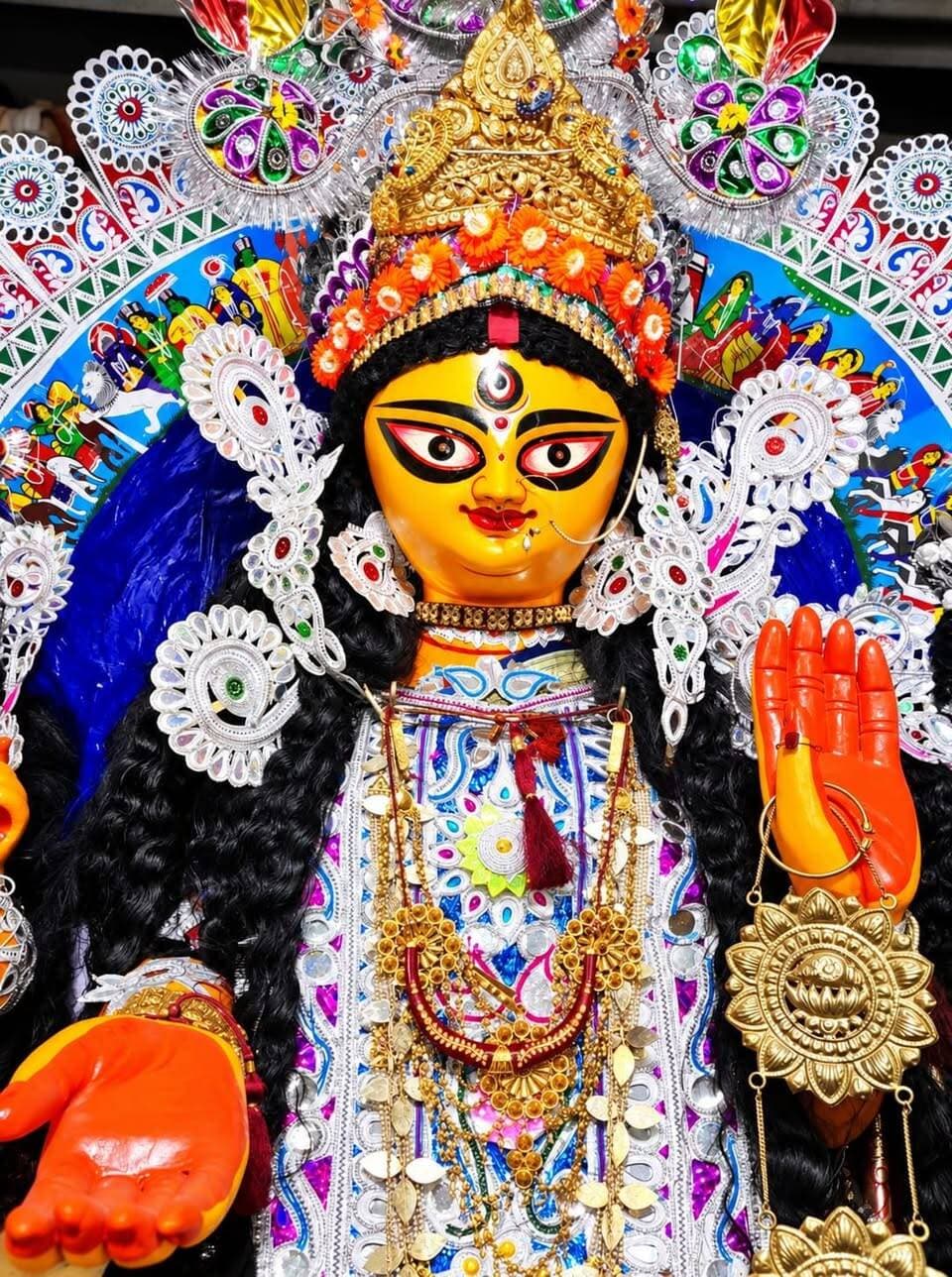 *দশভুজা নন, অসুরও নেই—অভয়া রূপে পূজিতা মা, শিবপুরের পালবাড়ির পুজোয় আজও বেঁচে ৩৫৫ বছরের ইতিহাস*
Bengal icon news হাওড়া: দেবীর হাতে দশটি অস্ত্র নেই। নেই অসুর বধের দৃশ্যও। দুই হাত তুলে তিনি যেন অভয় দেন তাঁর আপনজনদের। পাশে এক চালায় লক্ষ্মী, সরস্বতী, কার্তিক ও গণেশ। দেবী এখানে মহিষাসুরমর্দিনী নন, তিনি ‘অভয়া’। হাওড়ার শিবপুরের পালবাড়ির দুর্গাপুজোর এই স্বাতন্ত্র্যই তাকে অন্য বনেদি বাড়ির পুজোর থেকে আলাদা করে চেনায়। এবার সেই পুজো পা দিল ৩৫৫ বছরে। সময় বদলেছে, বদলেছে চারপাশের পুজোর জৌলুস, কিন্তু পালবাড়ির ঠাকুরদালানে আজও টিকে রয়েছে কয়েক শতাব্দীর লোকাচার, বিশ্বাস আর পারিবারিক আবেগ। হাওড়ার অন্যতম প্রাচীন এই পুজোর সূচনা করেছিলেন সর্বেশ্বর পাল। একসময় ধুমধাম করে পুজো হত। পরে সর্বেশ্বরবাবু পুজোর দায়িত্ব তুলে দেন বটকৃষ্ণ পালের হাতে। সেই থেকে প্রজন্মের পর প্রজন্ম ধরে পাল পরিবারের সদস্যরাই মায়ের আরাধনা করে আসছেন। কথিত আছে, এই দেবী আসলে অসুরবিনাশী নন। তিনি ‘অভয়া’—ভক্তের ভয় হরণকারী মায়ের রূপ। কুমোরটুলির শিল্পী বংশপরম্পরায় এই বাড়ির প্রতিমা গড়ে আসছেন। শুধু মৃৎশিল্পী নন, ঢাকিরাও বংশের ধারাবাহিকতা বজায় রেখে বছরের পর বছর এই পুজোর সঙ্গে যুক্ত। মহালয়ার পর থেকেই চণ্ডীপাঠের মাধ্যমে শুরু হয় পুজোর আবহ। শুক্লা তিথিতে মায়ের বোধন। সপ্তমীতে কলাবউ বা নবপত্রিকার স্নান গঙ্গায় নয়, হয় বাড়ির অন্দরেই। কিন্তু এই পুজোর সবচেয়ে আলোচিত এবং প্রাচীন লোকাচারগুলির একটি হল পশুবলি। সপ্তমীতেই মায়ের প্রাণপ্রতিষ্ঠার পর পাঁঠাবলি হয়। অষ্টমীর পুজোয় অবশ্য বলির রীতি নেই। পরিবারের ৩০-৪০ জন মহিলা একসঙ্গে ধুনোপোড়ানোর পর হয় সন্ধিপুজো। সেই সময় রয়েছে পাঁঠাবলির প্রথা। নবমীর সকালে বাড়ির ভোগের সময় আরও একটি পাঁঠাবলি হয়। এরপর পাঁচটি ফলের বলি এবং সবশেষে মহিষ বলি। হ্যাঁ, ৩৫৫ বছরের পুরনো এই পুজোয় আজও মহিষ বলির রীতি চলে আসছে। বলি যাঁরা দেন তাঁরাই মহিষের দেহ নিয়ে যান। শুধু মাথাটি নিয়ে যাওয়া হয় গঙ্গায়। তবে পুজোর একেবারে শুরুর দিকে এই রীতি ছিল না। এর পিছনেও রয়েছে এক আশ্চর্য লোককথা। কথিত আছে, শিবপুরের রায়চৌধুরী পরিবারের দুর্গাপুজোয় পালবাড়ির দেবী ‘অভয়া’র বোন ‘মায়া’কে দুর্গারূপে পুজো করা হত। সেই রায়চৌধুরী বাড়িতে ছিল মহিষ বলির প্রথা। একবার নাকি সেখান থেকে একটি মহিষ হাঁড়িকাঠে মাথা দিয়ে শিবপুরের পালবাড়িতে চলে আসে। সেই ঘটনাকেই ঘিরে পরে পালবাড়িতে শুরু হয় মহিষ বলির রীতি। নবমীর পুজো শেষে মায়ের হোম ও দক্ষিণান্তর হয়। তারপর শুরু হয় বিসর্জনের প্রস্তুতি। দশমীতে বাড়ির মহিলারা সিঁদুর খেলায় মেতে ওঠেন। কয়েক শতাব্দীর পুরনো এই পুজো আজ আগের মতো হয়তো জাঁকজমকপূর্ণ নয়। সময়ের সঙ্গে কমেছে জৌলুস, বেড়েছে আয়োজন চালিয়ে যাওয়ার চাপ। তবু ঐতিহ্যের সঙ্গে আপস করেনি পরিবার। পুজোর খরচ চালাতে পরিবারের পক্ষ থেকে তৈরি করা হয়েছে একটি ট্রাস্ট। সেই তহবিলে সঞ্চিত অর্থ থেকেই হয় মায়ের পুজো। আজ যখন থিমের পুজোর রমরমা, তখনও পালবাড়ি আঁকড়ে ধরে রেখেছে পুরনো দিনের নিয়মকানুন। তাই শিবপুরের পালবাড়ির পুজো শুধু ৩৫৫ বছরের একটি সংখ্যা নয়। এটি এক পরিবারের শিকড়ের গল্প, হারিয়ে যেতে বসা লোকাচারের গল্প, পূর্বপুরুষের বিশ্বাস আঁকড়ে ধরে বর্তমান প্রজন্মের এগিয়ে চলার গল্প। ঝলমলে থিমের ভিড়ে যখন বদলে যাচ্ছে পুজোর চেনা চেহারা, তখনও পালবাড়ির ঠাকুরদালানে দুই হাত তুলে ‘অভয়া’ যেন বলে চলেছেন—সময় বদলাক, প্রজন্ম বদলাক, কিন্তু ঐতিহ্যের প্রদীপটি যেন নিভে না যায়।