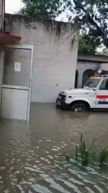 हरदोई में भारी बारिश का कहर: बेहटा गोकुल थाना परिसर बना तालाब, थाने के अंदर तक घुसा पानी
उत्तर प्रदेश के हरदोई जिले में मूसलाधार बारिश ने भारी तबाही मचाई है। लगातार हो रही तेज बारिश के कारण हरदोई का बेहटा गोकुल थाना परिसर पूरी तरह से जलमग्न हो गया है। स्थिति इतनी भयावह हो चुकी है कि बारिश का पानी पुलिस थाने के कमरों और कार्यालयों के भीतर तक भर गया है।
तलाब में तब्दील हो चुके थाना परिसर के कारण पुलिसकर्मियों को प्रशासकीय कामकाज निपटाने में भारी मुश्किलों का सामना करना पड़ रहा है। वहीं अपनी शिकायतें लेकर थाने पहुँचने वाले फरियादियों को भी जलभराव के बीच से होकर गुजरना पड़ रहा है, जिससे उन्हें काफी परेशानियों से जूझना पड़ रहा है। थाना परिसर में खड़ी सरकारी गाड़ियाँ भी पानी में डूबी हुई नज़र आ रही हैं।