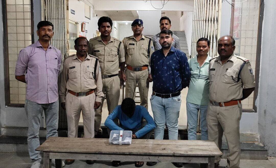बागली में अवैध रिवॉल्वर और कारतूस के साथ युवक गिरफ्तार
कॉलेज ग्राउंड में घूम रहा था हथियार लेकर, पुलिस ने घेराबंदी कर दबोचा; आर्म्स एक्ट में केस दर्ज
देवास/बागली। अवैध हथियारों के खिलाफ चलाए जा रहे ऑपरेशन प्रहार के तहत बागली पुलिस ने एक युवक को अवैध देशी रिवॉल्वर और जिंदा कारतूस के साथ गिरफ्तार किया है। पुलिस के मुताबिक आरोपी कॉलेज ग्राउंड, गांधी कॉलोनी में हथियार लेकर घूम रहा था। सूचना मिलने पर पुलिस टीम ने मौके पर पहुंचकर घेराबंदी की और तलाशी के दौरान हथियार बरामद किया।
पुलिस के अनुसार 27 सितंबर को मुखबिर से सूचना मिली थी कि कॉलेज ग्राउंड, गांधी कॉलोनी बागली में एक व्यक्ति के पास अवैध देशी रिवॉल्वर और कारतूस है। सूचना पर अतिरिक्त पुलिस अधीक्षक ग्रामीण सौम्या जैन के मार्गदर्शन और एसडीओपी बागली संजय सिंह बैस के निर्देशन में थाना प्रभारी जीवन भिडोरे के नेतृत्व में टीम मौके पर पहुंची।
पुलिस ने घेराबंदी कर रवि उर्फ बदिया पिता रामचन्द्र यादव (29), निवासी चापड़ा को पकड़ा। तलाशी में उसके कब्जे से एक अवैध देशी रिवॉल्वर और एक जिंदा कारतूस बरामद किया गया।
आर्म्स एक्ट में मामला दर्ज
पुलिस ने हथियार और कारतूस जब्त कर आरोपी को गिरफ्तार कर लिया। उसके खिलाफ थाना बागली में अपराध क्रमांक 401/2026, धारा 25 और 27 आर्म्स एक्ट के तहत मामला दर्ज कर जांच शुरू की गई है।
कार्रवाई में थाना प्रभारी जीवन भिडोरे, उप निरीक्षक गब्रिएल एक्का, प्रधान आरक्षक रामप्रताप सिंह चौहान, आरक्षक अनिल सिंह और आरक्षक विशाल चन्द्रवंशी की भूमिका रही।
नोट: पुलिस के अनुसार आरोपी से हथियार बरामद हुआ है और उसके खिलाफ मामला दर्ज किया गया है; आगे की कानूनी प्रक्रिया और विवेचना जारी है।