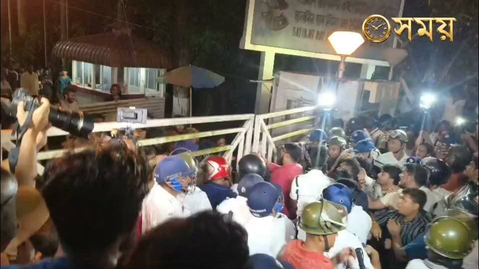 রণক্ষেত্র মুকুন্দপুরের চলচ্চিত্র শিক্ষাঙ্গন! SRFTI-এর অডিটোরিয়ামে ‘বহিরাগতদের’ উস্কানিমূলক ভাষণের অভিযোগ, পুলিশ মোতায়েন সত্ত্বেও র*ক্তক্ষয়ী সং*ঘর্ষে আহত একাধিক পড়ুয়া ও শিক্ষক।
বিস্তারিত:রবিবার কলকাতার মুকুন্দপুরে অবস্থিত সত্যজিৎ রায় ফিল্ম অ্যান্ড টেলিভিশন ইনস্টিটিউট (SRFTI) চত্বর এক নজিরবিহীন ও র*ক্তক্ষয়ী সং*ঘর্ষের সাক্ষী হলো । প্রতিষ্ঠানের অডিটোরিয়ামে আয়োজিত একটি বহিরাগত সংগঠনের অনুষ্ঠানকে কেন্দ্র করে শুরু হওয়া রাজনৈতিক বাকবিতণ্ডা চরম আকার নেয়, যা পরবর্তীতে পুলিশ বাহিনীর উপস্থিতিতেই র*ক্তক্ষয়ী সং*ঘর্ষ ও মারা*মারিতে রূপ নেয় । পরিস্থিতি নিয়ন্ত্রণে আনতে ঘটনাস্থলে বিশাল পুলিশ বাহিনী মোতায়েন করা হলেও দীর্ঘক্ষণ ক্যাম্পাস জুড়ে উত্তেজনা বজায় থাকে।
রবিবার বেলা ১২টা থেকে বিকেল ৪টে পর্যন্ত প্রতিষ্ঠানের মূল অডিটোরিয়াম বা সভাঘরটি ভাড়া নিয়েছিল ‘অখিল ভারতীয় গ্রাহক পঞ্চায়েত’ নামের একটি সংগঠন। অভিযোগ, সেই অনুষ্ঠান চলাকালীন মঞ্চ থেকে কিছু ব্যক্তি অত্যন্ত উগ্র ও রাজনৈতিক উস্কানিমূলক ভাষণ দিচ্ছিলেন ক্যাম্পাসের সাধারণ পড়ুয়ারা এর তীব্র প্রতিবাদ জানান এবং প্রশ্ন তোলেন যে কেন একটি প্রথম সারির জাতীয় চলচ্চিত্র শিক্ষা প্রতিষ্ঠানের ভেতর এই ধরনের উস্কানিমূলক রাজনৈতিক প্রচার চালানো হচ্ছে।
ঘটনার পর উত্তেজনা চরম মাত্রায় পৌঁছালে ক্ষুব্ধ পড়ুয়ারা SRFTI-এর প্রধান ফটক বা গেট আটকে ভেতরে অবস্থান বিক্ষোভ ও 'গো ব্যাক' স্লোগান দিতে শুরু করেন । অন্য দিকে, গেটের বাইরে জড়ো হয়ে পাল্টা 'জয় শ্রী রাম' স্লোগান দিতে থাকেন অখিল ভারতীয় গ্রাহক পঞ্চায়েতের সদস্যরা । তাঁদের অভিযোগ, সংগঠনের বেশ কিছু সদস্যকে পড়ুয়ারা ভেতরে আটকে রেখেছেন এবং তাঁদের নিরাপদে বের করতে না দিলে তাঁরা আরও লোক নিয়ে আসবেন।ঘটনাস্থলে পূর্ব যাদবপুর থানার বিশাল পুলিশ বাহিনী উপস্থিত হয়ে পরিস্থিতি সামাল দেওয়ার চেষ্টা করছে । গেটের বাইরে ও ভেতরে পুলিশি ব্যারিকেড তৈরি করা হয়েছে এবং আহত শিক্ষার্থীদের চিকিৎসার ব্যবস্থা করা হয়েছে