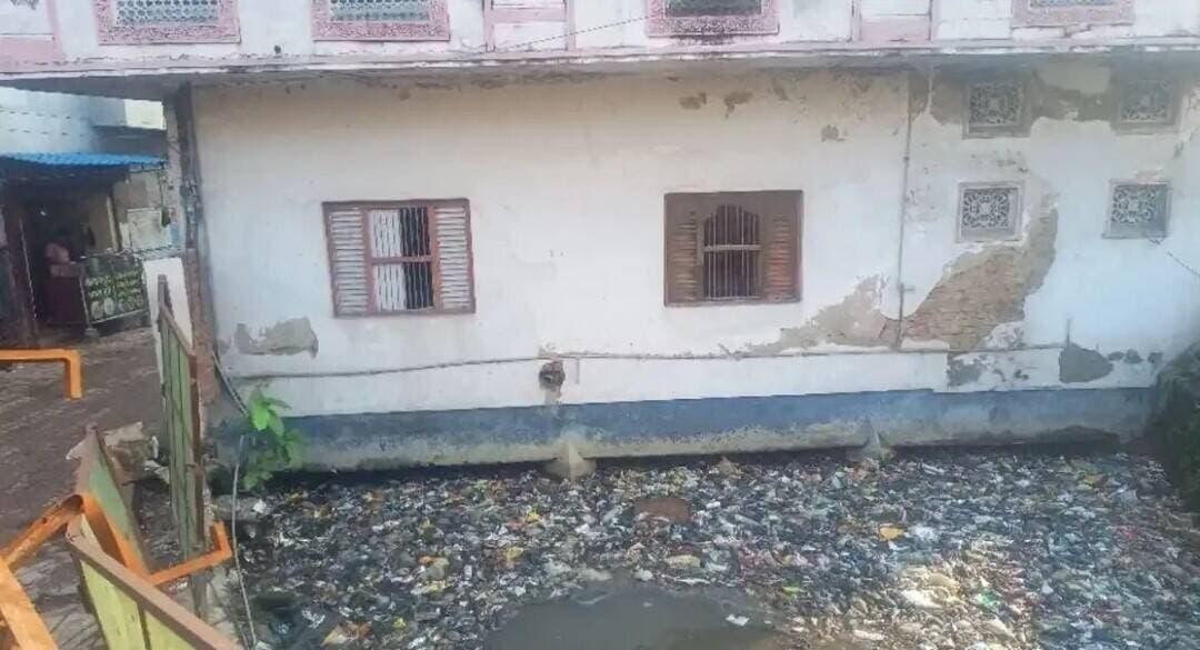 6 दशक पुराना लीज, 17 साल का बकाया; गोरखपुर में जलभराव का कारण बना दो मंजिला मकान दीपावली के बाद होगा ध्वस्त
गोरखपुर। विजय चौराहा, सुमेरसागर, दिलेजाकपुर और पुर्दिलपुर में जलभराव का बड़ा कारण बने नाले को दीपावली के बाद अतिक्रमण से मुक्त कराया जाएगा। नगर निगम की ओर से नाले के ऊपर बने मकान को ध्वस्त कर पानी के बहाव को दुरुस्त करने की कार्रवाई की जाएगी।
मानसून की शुरुआत में इन इलाकों में जलभराव की पड़ताल के दौरान नाले पर बने मकान संबंधी खबर तस्वीरों के साथ प्रमुखता से प्रकाशित की गई थी। इसके बाद नगर निगम ने मामले को गंभीरता से लेते हुए कार्रवाई शुरू की।
नाले पर बने मकान को हटाने के लिए नगर निगम की ओर से मकान मालिक को पहले ही नोटिस जारी किया जा चुका है। निर्माण हटाने के लिए नगर निगम बोर्ड से भी मंजूरी मिल चुकी है। अब दीपावली के बाद नोटिस के अनुसार आगे की कार्रवाई शुरू की जाएगी। मकान के निचले हिस्से में दुकानें संचालित होने के कारण त्योहार तक कार्रवाई में राहत दी गई है।
नाले पर मकान बनने से पानी का प्रवाह पूरी तरह बाधित हो जाता है। वर्षा के दौरान आसपास के क्षेत्रों का पानी नाले में पहुंचने के बाद यहां रुक जाता है। इससे विजय चौराहा से लेकर सुमेरसागर, दिलेजाकपुर और पुर्दिलपुर तक जलभराव की स्थिति बनती है। स्थानीय लोगों के मुताबिक नाले की क्षमता के अनुरूप पानी का बहाव नहीं हो पाने से समस्या और गंभीर हो जाती है।
नाले के दोनों तरफ कुल छह दुकानें हैं। मकान मालिक अजीत अग्रवाल ने दुकानदारों से भी दुकानें खाली करने के लिए कहा है, ताकि नगर निगम की कार्रवाई में किसी तरह की बाधा न आए। नगर निगम की ओर से कार्रवाई की तैयारी पूरी कर ली गई है।
अजीत अग्रवाल ने बताया कि नगर निगम की ओर से जारी नोटिस का जवाब दिया जा चुका है। उन्होंने कहा कि नगरपालिका बोर्ड की ओर से मकान निर्माण की अनुमति मिली थी। इसके बावजूद अब नगर निगम की ओर से नाले को अतिक्रमण से मुक्त कराने की कार्रवाई की जा रही है।
वहीं, नगर निगम अधिकारियों का कहना है कि नाले का रास्ता साफ होने के बाद पानी के बहाव में सुधार होगा और आसपास के मोहल्लों में जलभराव की समस्या कम करने में मदद मिलेगी।
छह दशक पहले नाले पर मिली लीज, 2009 से किराया बंद... फिर भी मकान खड़ा रहा
विजय चौराहा, सुमेरसागर, दिलेजाकपुर और पुर्दिलपुर के लोगों को हर वर्ष जलभराव से जूझना पड़ता रहा। सवाल यह है कि जिस करीब 40 फीट चौड़े नाले पर बना दो मंजिला मकान अब जलनिकासी में बड़ी अड़चन माना जा रहा है, वह इतने वर्षों तक नगर निगम की नजर से कैसे बचा रहा?
नगर निगम की जांच में सामने आया कि नाले की भूमि पर मकान बनाने के लिए 1967 में तत्कालीन नगरपालिका में अजीत अग्रवाल और आनंद अग्रवाल ने लीज के लिए आवेदन किया था। प्रक्रिया पूरी होने के बाद अनुमति भी दे दी गई। यानी नाले की भूमि पर निर्माण की नींव करीब छह दशक पहले ही पड़ गई थी। लंबे समय तक संपत्ति कर और दुकानों का किराया भी जमा होता रहा।
इसके अलावा सवाल यह भी उठता है कि जब 2009 के बाद से संपत्ति कर और किराया तक जमा नहीं हुआ तो कार्रवाई में 17 साल क्यों लग गए?
विजय चौराहा क्षेत्र में जलभराव की समस्या बार-बार सामने आने और जागरण में नाले पर बने मकान की तस्वीर के साथ खबर प्रकाशित होने के बाद नगर निगम ने जांच शुरू की। अब निगम ने जलनिकासी में बाधा और कर-किराया बकाया होने का हवाला देते हुए नोटिस जारी किया है। नगर निगम बोर्ड से भी अनुमति मिल चुकी है। दीपावली के बाद मकान ध्वस्त होगा।
नाले पर बना मकान शहर की जलनिकासी में काफी ज्यादा बाधक बना हुआ है। इसकी वजह से विजय चौराहा समेत आसपास के मोहल्लों में पानी भर जाता है। इसको हटाया जाना जरूरी है। नगर निगम बोर्ड से नाले पर बने मकान को ध्वस्त करने की मंजूरी मिल चुकी है। दीपावली बाद इसकी कार्रवाई की जाएगी।