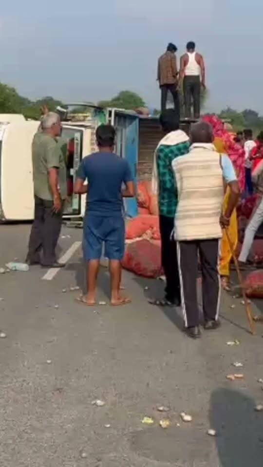 बघवारी मे बीच सडक मे पिकअप पलटा, चारो तरफ सब्जी बिखरी, ड्रायवर उसी के ऊपर सोया