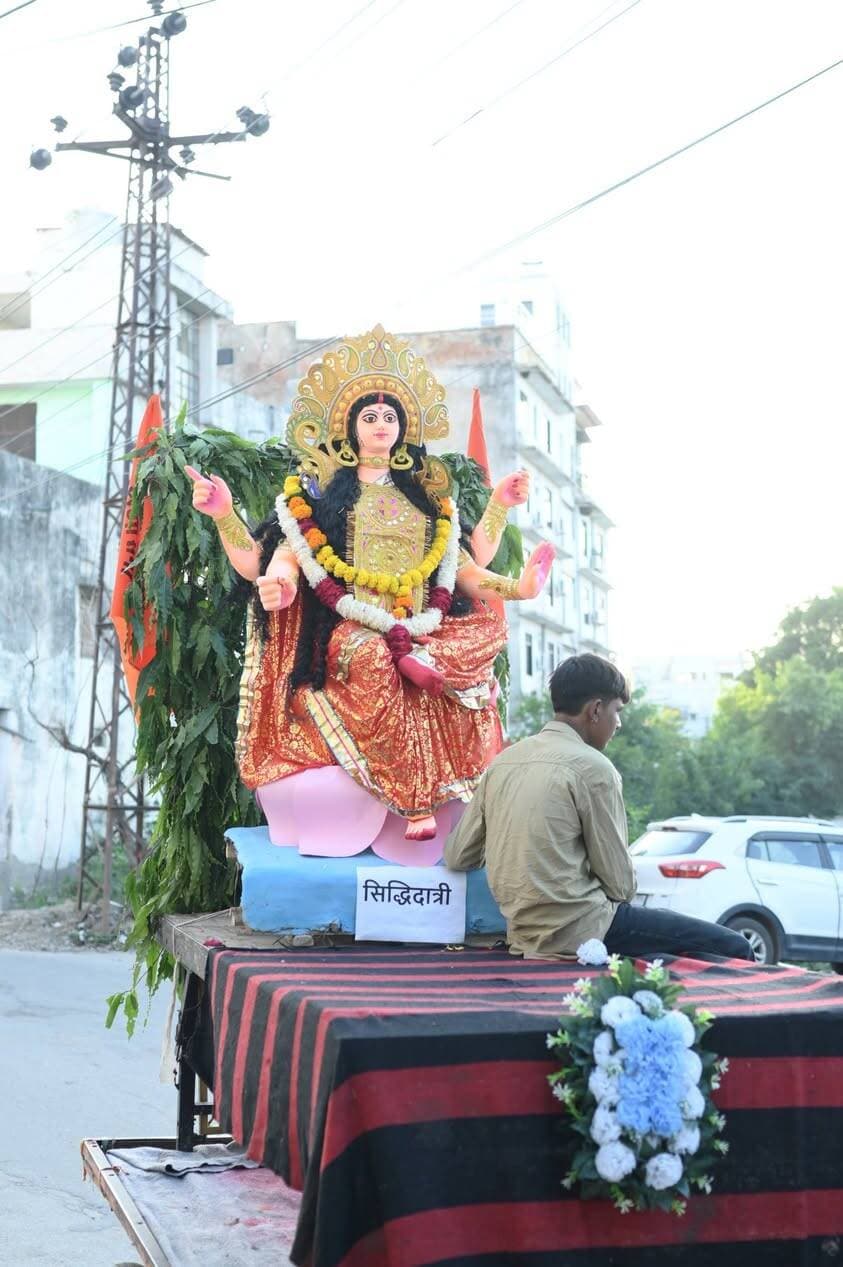 उदयपुर में शूलधारिणी सेना की भव्य शोभायात्रा में उमड़ा आस्था का सैलाब, 1000 से अधिक महिलाओं ने धारण किए कलश
नासिक ढोल की गूंज, शस्त्र प्रदर्शन और आकर्षक झांकियों ने बांधा समां, आवरी माता मंदिर में स्थापित किए गए नवदुर्गा स्वरूप
उदयपुर। नवरात्रि के पावन अवसर पर शनिवार को उदयपुर में शूलधारिणी सेना की ओर से निकाली गई भव्य शोभायात्रा में भक्ति, शक्ति और सनातन संस्कृति का अद्भुत संगम देखने को मिला। रेती स्टैंड स्थित आवरी माता मंदिर से रवाना हुई शोभायात्रा में 1000 से अधिक महिलाओं ने माता रानी की चुनरी ओढ़कर सिर पर कलश धारण किए और पूरे उत्साह के साथ भाग लिया। कलश धारण किए महिलाओं की कतारों और माता रानी के जयकारों से माहौल भक्तिमय हो उठा।
शोभायात्रा में नासिक ढोल की गूंज ने लोगों को आकर्षित किया, वहीं बाहुबली हनुमानजी, भगवान नरसिंह, शिव अघोरी मंडली और श्रीनाथजी की आकर्षक झांकियां लोगों के आकर्षण का केंद्र रहीं। अश्व नृत्य, लोक नृत्य और अखाड़े के कलाकारों ने अपनी प्रस्तुतियों से दर्शकों का मन मोह लिया। शस्त्र प्रदर्शन के दौरान वीरता और शौर्य की झलक देखने को मिली। मार्ग में श्रद्धालुओं ने उत्साह के साथ शोभायात्रा का स्वागत किया।
नवदुर्गा प्रतिमाओं की स्थापना, पर्यावरण संरक्षण का संदेश
शूलधारिणी सेना के जिलाध्यक्ष संदीप चौहान ने बताया कि शोभायात्रा टेकरी चौराहा, माली कॉलोनी, देवनारायण मंदिर, परशुराम चौराहा और राजेंद्र नगर होते हुए टेकरी स्कूल पहुंची। इसके बाद शोभायात्रा पुनः आवरी माता मंदिर लौटी, जहां नवदुर्गा स्वरूपों की प्रतिमाएं स्थापित की गईं।
आयोजन की विशेषता मिट्टी से निर्मित नवदुर्गा प्रतिमाएं रहीं, जिनके माध्यम से पर्यावरण संरक्षण का संदेश दिया गया। शूलधारिणी सेना पिछले 19 वर्षों से इस धार्मिक आयोजन को निरंतर करती आ रही है। आयोजन से पहले कार्यकर्ताओं ने घर-घर जाकर लोगों को निमंत्रण दिया था।
सेना के कार्यकर्ताओं ने संभाली व्यवस्थाएं
आयोजन में सेना संस्थापक गजेंद्र आचार्य, प्रदेश सचिव भूपेंद्र धाभाई, सेना उप प्रमुख सतीश मालवीय, जिलाध्यक्ष संदीप चौहान, नगर अध्यक्ष संजय सुथार, महेंद्र सिंह चौहान, नितिन सिंह गहलोत, प्रशांत तेली, सुनील निमावत, हरीश सालवी, महावीर प्रसाद शर्मा, शालीभद्र नागोरी और हार्दिक तेली सहित सेना के कार्यकर्ताओं ने सक्रिय भूमिका निभाई।
शोभायात्रा ने शहर में धार्मिक उत्साह के साथ भारतीय परंपरा, शौर्य और नारी शक्ति का संदेश दिया।