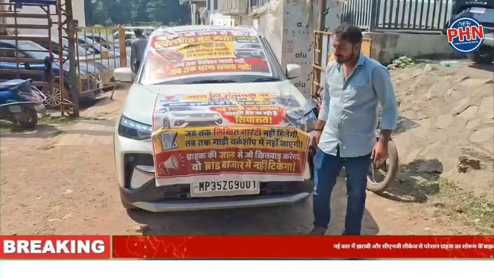 ग्राहक का अनोखा प्रदर्शन,नई कार में ख़राबी और सीएनजी लीकेज से परेशान ग्राहक का शोरूम के बाहर कार में बैनर लगाकर शुरू किया अनशन