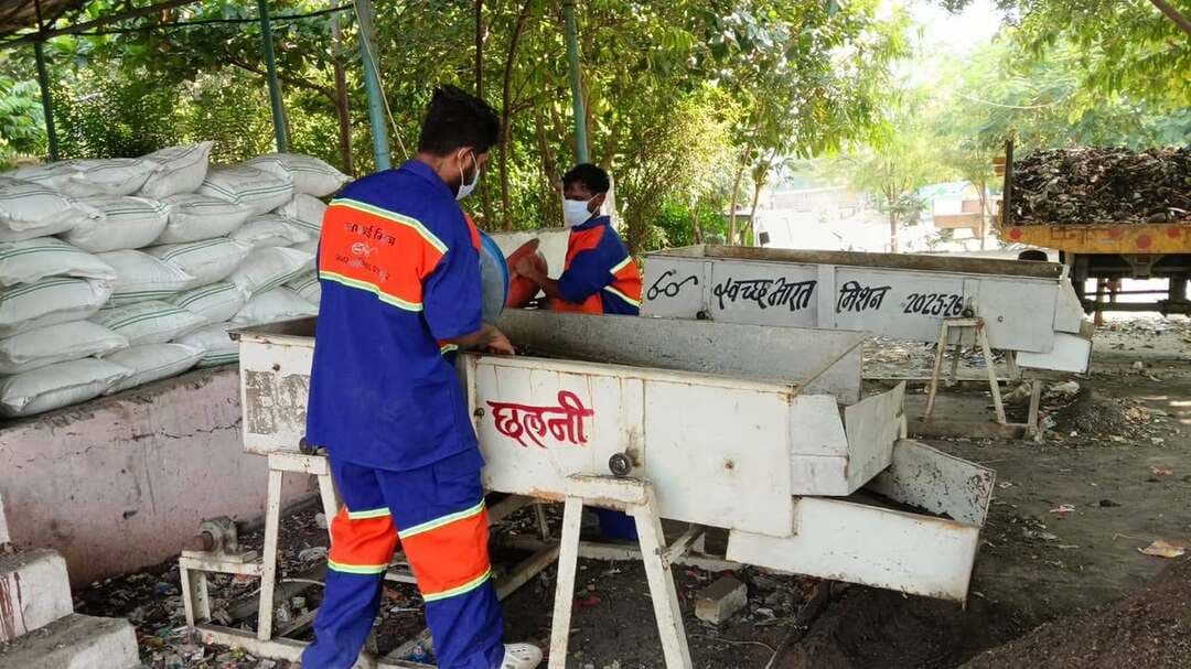 ✅ कचरे से खाद तक- #शाहपुर में स्वच्छता के साथ संसाधनों का भी हो रहा सदुपयोग
✅ घरों से निकलने वाले कचरे से तैयार हो रहा जैविक खाद
घरों से निकलने वाला कचरा अक्सर अनुपयोगी समझकर फेंक दिया जाता है, लेकिन सही प्रबंधन और वैज्ञानिक प्रक्रिया से यही कचरा उपयोगी संसाधन बन सकता है। नगर परिषद शाहपुर में कचरे से जैविक खाद तैयार करने की प्रक्रिया इसका अच्छा उदाहरण पेश कर रहा है। यहां घरों, दुकानों, होटलों और सब्जी मंडी से एकत्रित कचरे का पृथक्करण कर जैविक अपशिष्ट से खाद तैयार की जा रही है। इस प्रक्रिया से जहां स्वच्छता बनाए रखने में मदद मिलती है, वहीं कचरे का उपयोगी रूपांतरण भी सुनिश्चित होता है।
✅ सुबह से शुरू होती है स्वच्छता की जिम्मेदारी
नगर परिषद शाहपुर में प्रतिदिन सुबह सफाई कार्य की शुरुआत होती है। परिषद के प्रांगण में 60 सफाई मित्र और 10 वाहन चालक एकत्रित होते हैं। निर्धारित रूट चार्ट के अनुसार 9 कचरा संग्रहण वाहन 15 वार्डों में सफाई व्यवस्था के लिए रवाना होते हैं। ये वाहन घरों, दुकानों, होटलों और सब्जी मंडी से कचरा एकत्रित करते हैं। इस व्यवस्था में नागरिकों की सहभागिता भी महत्वपूर्ण रहती है। गीले कचरे को हरे डिब्बे में और सूखे कचरे को नीले डिब्बे में अलग-अलग रखने से कचरे के बेहतर प्रबंधन में सहायता मिलती है।
✅ कचरे का पृथक्करण एवं रीसाइक्लिंग
विभिन्न वार्डों से एकत्रित कचरे को ट्रेचिंग ग्राउंड तक पहुंचाया जाता है। यहां निर्धारित प्लेटफॉर्म और शेड में कचरा उतारने के बाद सावधानी एवं सुरक्षा उपकरणों के साथ सफाई मित्र दस्ताने एवं मास्क पहनकर उसका पृथक्करण करते हैं। इस दौरान प्लास्टिक, कागज, गत्ता, धातु, कांच और कपड़े जैसी सामग्री अलग-अलग की जाती है। रीसाइक्लिंग योग्य सूखे कचरे को गठानों के रूप में तैयार कर #रीसाइक्लिंग के लिए भेजा जाता है। वहीं, फल-सब्जियों के छिलके, फूल, चायपत्ती तथा घरों एवं सार्वजनिक स्थलों से निकलने वाला बचा हुआ भोजन जैसे जैविक कचरे को अलग रखा जाता है।
✅ लगभग 45 दिनों में तैयार होती है जैविक खाद
#जैविक कचरे को कम्पोस्ट शेड में निर्धारित स्थान पर विंडरो में रखा जाता है। खाद बनाने की प्रक्रिया को बेहतर बनाने के लिए इसमें सूक्ष्मजीव कल्चर के रूप में छाछ एवं गुड़ के पानी का छिड़काव किया जाता है। इसके साथ ही कचरे की नियमित पलटाई की जाती है तथा नमी और तापमान पर निगरानी रखी जाती है। इस प्रक्रिया के माध्यम से लगभग 45 दिनों में जैविक खाद तैयार हो जाता है। तैयार खाद को छलनी मशीन से छाना जाता है, जिससे बारीक और उपयोग के लिए तैयार खाद अलग हो जाती है। बचा हुआ मोटा अंश पुनः प्रक्रिया में शामिल कर दिया जाता है।
✅ खाद से किसानों और #बागवानी को लाभ
खाद तैयार होने के बाद उसकी तौल एवं पैकिंग की जाती है। पैकेट पर ‘जैविक खाद- नगर परिषद शाहपुर’ का लेबल लगाया जाता है। इसके बाद यह खाद किसानों, उद्यानों, नर्सरियों और नागरिकों को 4 रुपये प्रति किलोग्राम की दर से उपलब्ध कराई जाती है। एक बैग में 50 किलोग्राम खाद होती है, जिसकी कीमत 200 रुपये निर्धारित है। प्राप्त राशि का उपयोग नगर परिषद द्वारा नगर के विकास कार्यों एवं क्षेत्र के नागरिकांे की मूलभूत सुविधाओं में विस्तार के लिये किया जाता है।
नगर परिषद शाहपुर का यह प्रयास दर्शाता है कि उचित कचरा प्रबंधन से अपशिष्ट को उपयोगी संसाधन में बदला जा सकता है। कचरे का पृथक्करण, पुनर्चक्रण योग्य सामग्री का उपयोग और जैविक खाद का निर्माण #स्वच्छता के साथ संसाधनों के सदुपयोग की दिशा में अच्छी पहल हैं। नागरिकों की सहभागिता एवं प्रशासन के सहयोग से नगरीय विकास में बदलाव आ रहे है।
CM Madhya Pradesh Department of Urban Development & Housing MP Jansampark Madhya Pradesh Nagar Parishad Shahpur #सेवा_संकल्प_अभियान #SevaSankalpAbhiyan #बुरहानपुर #burhanpur #MadhyaPradesh #कहानी_बदलाव_की #सफलता_की_कहानी
#CleanIndia #shahpur