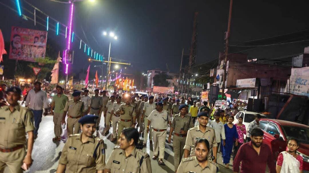 माता टेकरी पर देर रात तक उमड़ा आस्था का सैलाब, सुरक्षा में मुस्तैद रही देवास पुलिस
नवरात्रि के सातवें दिन हजारों श्रद्धालुओं ने किए माता के दर्शन, एसपी पुनीत गेहलोद ने संभाली व्यवस्था की कमान; CCTV से होती रही निगरानी
देवास। शारदीय नवरात्रि के सातवें दिन शनिवार देर रात तक माता टेकरी पर श्रद्धालुओं का जनसैलाब उमड़ता रहा। मां चामुंडा और मां तुलजा के दर्शन के लिए हजारों की संख्या में पहुंचे श्रद्धालुओं के बीच सुरक्षा और यातायात व्यवस्था बनाए रखने के लिए देवास पुलिस मुस्तैद रही। भीड़ के दबाव को देखते हुए पुलिस ने प्रमुख दर्शन मार्गों, प्रवेश-निकास द्वारों और आसपास के यातायात मार्गों पर विशेष निगरानी रखी।
पुलिस अधीक्षक पुनीत गेहलोद ने देर रात माता टेकरी परिसर और प्रमुख दर्शन मार्गों का निरीक्षण कर सुरक्षा एवं भीड़ प्रबंधन व्यवस्थाओं का जायजा लिया। उन्होंने ड्यूटी पर तैनात पुलिस अधिकारियों और कर्मचारियों को श्रद्धालुओं की आवाजाही सुचारु रखने तथा दर्शन के दौरान किसी प्रकार की असुविधा न होने देने के निर्देश दिए।
CCTV से निगरानी, मैदान में तैनात रहा पुलिस बल
माता टेकरी स्थित कंट्रोल रूम से CCTV कैमरों के जरिए दर्शन मार्गों, प्रवेश-निकास द्वारों और आसपास के यातायात की लगातार निगरानी की गई। भीड़ की स्थिति के अनुसार मैदानी पुलिस बल के साथ समन्वय बनाकर श्रद्धालुओं के आवागमन को व्यवस्थित रखने के प्रयास किए गए। देर रात तक पुलिस अधिकारी और कर्मचारी अपने निर्धारित स्थानों पर तैनात रहे, ताकि भीड़ के बीच सुरक्षा व्यवस्था और यातायात सुचारु बना रहे।
श्रद्धालुओं से सहयोग की अपील
देवास पुलिस ने श्रद्धालुओं से निर्धारित मार्गों का उपयोग करने, कतारबद्ध होकर दर्शन करने और अनावश्यक भीड़ नहीं लगाने की अपील की है। साथ ही पुलिस एवं प्रशासन के निर्देशों का पालन करने और आपात स्थिति में डायल 112 पर संपर्क करने की सलाह दी है।