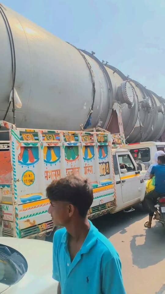 🚨 बेल्जियम से #लखीमपुर तक का सफर… रास्ते में पुल बने बाधा, कहीं बनाना पड़ा वैकल्पिक रास्ता, तो कहीं हटाने पड़े फुट ओवरब्रिज के हिस्से! आखिरकार #खीरी की धरती पर पहुंचा 308 पहियों वाला महाबली।
दुनियाभर में चर्चा बटोर रहा 308 पहियों वाला विशालकाय ट्रक मंगलवार रात लखीमपुर खीरी जिले में दाखिल हो गया। इस पर लदा करीब 200 टन का विशाल वेसल बलरामपुर चीनी मिल की कुंभी इकाई में स्थापित किया जाना है, जहां बायोपॉलिमर निर्माण से जुड़ी परियोजना विकसित की जा रही है।
इस महाबली का सफर किसी चुनौती से कम नहीं रहा। बेल्जियम से समुद्री मार्ग के जरिए ओडिशा के पारादीप बंदरगाह पहुंची मशीन को वहां से सड़क मार्ग द्वारा झारखंड, बिहार और उत्तर प्रदेश के रास्ते लखीमपुर लाया गया।
📍 रास्ते में क्या-क्या हुआ?
▪️ भारी वजन और विशाल आकार के कारण कई जगह वैकल्पिक रास्तों की व्यवस्था करनी पड़ी।
▪️ वाराणसी में ट्रक को निकालने के लिए फुट ओवरब्रिज के हिस्सों को काटकर हटाया गया और क्रेन की मदद से पुल को ऊपर उठाकर रास्ता बनाया गया।
▪️ कुछ स्थानों पर सड़क की स्थिति और दलदली जमीन के कारण भी आगे बढ़ने में मुश्किलें आईं।
▪️ इस विशेष ट्रेलर के साथ इंजीनियरों और तकनीकी कर्मचारियों की टीम भी चल रही है। एक रिपोर्ट के मुताबिक, इसके सफर में रोजाना लगभग 200 से 300 लीटर डीजल खर्च हो रहा था।
अब सैकड़ों किलोमीटर की मुश्किल यात्रा तय करने के बाद यह विशालकाय ट्रक लखीमपुर खीरी पहुंच चुका है। 308 पहियों पर लदी इस भारी मशीन को देखने के लिए रास्ते में लोगों की भीड़ उमड़ रही है।
यह सिर्फ एक ट्रक नहीं, बल्कि भारी इंजीनियरिंग, तकनीक और लंबे इंतजार के बाद मंजिल तक पहुंचने की कहानी है।
📢 लखीमपुर के लोगों, क्या आपने 308 पहियों वाले इस महाबली को देखा? अपनी प्रतिक्रिया कमेंट में जरूर बताएं।
#LakhimpurKheri #308Wheels #Kumbhi #ApnaLakhimpur
