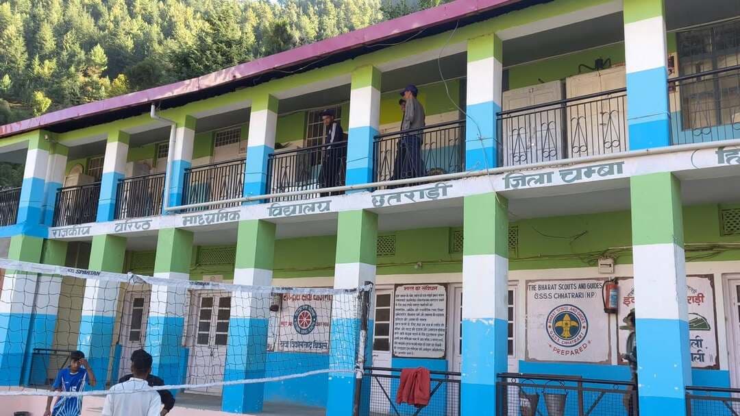 *सीनियर सेकेंडरी स्कूल छतराड़ी स्कूल में शिक्षा व्यवस्था बदहाल, प्रवक्ताओं के छह पद खाली; क्लेरिकल स्टाफ भी शून्य*
*अंग्रेजी, हिंदी, बायोलॉजी, केमिस्ट्री, राजनीति विज्ञान और अर्थशास्त्र के प्रवक्ताओं के पद लंबे समय से रिक्त, शिक्षकों पर पढ़ाई के साथ कार्यालयी कामकाज का भी बोझ*
*लेक्चर थिएटर, शौचालय, रसोईघर और खेल मैदान जैसी सुविधाओं का अभाव; प्रबंधन कमेटी के अध्यक्ष सुखपाल शर्मा ने सरकार और शिक्षा विभाग से उठाई पद भरने की मांग*
हिमाचल 84 टीवी ब्यूरो | छतराड़ी (चंबा)
जिला चंबा के सबसे पुराने शिक्षण संस्थानों में शामिल राजकीय वरिष्ठ माध्यमिक पाठशाला छतराड़ी में शिक्षकों और गैर-शिक्षक कर्मचारियों की कमी के चलते शिक्षा व्यवस्था प्रभावित हो रही है। स्कूल में प्रवक्ताओं के छह महत्वपूर्ण पद लंबे समय से रिक्त पड़े हैं, जबकि कार्यालय का कामकाज संभालने के लिए क्लेरिकल स्टाफ का भी एक कर्मचारी उपलब्ध नहीं है। इसके चलते जहां विद्यार्थियों की पढ़ाई प्रभावित हो रही है, वहीं स्कूल में कार्यरत शिक्षकों पर अध्यापन के साथ-साथ प्रशासनिक और कार्यालय संबंधी कार्यों का अतिरिक्त बोझ पड़ रहा है। स्टाफ की कमी के साथ-साथ स्कूल में आधारभूत सुविधाओं का अभाव भी चिंता का विषय बना हुआ है।
जानकारी के अनुसार स्कूल में अंग्रेजी, हिंदी, जीव विज्ञान, रसायन विज्ञान, राजनीति विज्ञान और अर्थशास्त्र विषयों के प्रवक्ताओं के पद खाली चल रहे हैं। ये सभी महत्वपूर्ण विषय हैं और वरिष्ठ माध्यमिक स्तर पर विद्यार्थियों की शैक्षणिक तैयारी में इनकी अहम भूमिका रहती है। विषय विशेषज्ञ प्रवक्ताओं की अनुपलब्धता के कारण विद्यार्थियों को नियमित पढ़ाई और पाठ्यक्रम पूरा करने में कठिनाइयों का सामना करना पड़ रहा है। विशेषकर बोर्ड परीक्षाओं की तैयारी कर रहे विद्यार्थियों के लिए यह स्थिति अधिक चुनौतीपूर्ण बन सकती है। ऐसे में अभिभावकों की चिंता भी बढ़ना स्वाभाविक है कि उनके बच्चों की पढ़ाई और परीक्षा परिणाम पर इसका क्या असर पड़ेगा।
स्कूल में केवल शिक्षकों की कमी ही समस्या नहीं है, बल्कि गैर-शिक्षक कर्मचारियों के पद भी रिक्त पड़े हैं। क्लर्क, असिस्टेंट और सुपरिंटेंडेंट के पद खाली होने के कारण स्कूल का पूरा कार्यालयी कामकाज प्रभावित हो रहा है। क्लेरिकल स्टाफ का एक भी कर्मचारी नहीं होने से शिक्षकों को ही पढ़ाई के अलावा कार्यालय से जुड़े कार्य भी संभालने पड़ रहे हैं। इससे शिक्षकों का बहुमूल्य समय प्रशासनिक कार्यों में खर्च हो रहा है। शिक्षकों की प्राथमिक जिम्मेदारी विद्यार्थियों को पढ़ाना है, लेकिन कर्मचारियों की कमी के चलते उन्हें अतिरिक्त जिम्मेदारियां निभानी पड़ रही हैं।
स्कूल में आधारभूत सुविधाओं की स्थिति भी संतोषजनक नहीं बताई जा रही है। यहां लेक्चर थिएटर, शौचालय, रसोईघर और खेल मैदान जैसी आवश्यक सुविधाओं का अभाव बना हुआ है। विद्यार्थियों के सर्वांगीण विकास के लिए पढ़ाई के साथ खेलकूद और अन्य गतिविधियों के लिए उचित व्यवस्था होना भी जरूरी है। खेल मैदान के अभाव में विद्यार्थियों को अपनी खेल प्रतिभा प्रदर्शित करने और उसे निखारने के पर्याप्त अवसर नहीं मिल पा रहे हैं। वहीं, अन्य बुनियादी सुविधाओं की कमी भी स्कूल के समग्र शैक्षणिक वातावरण को प्रभावित कर रही है।
कई बार सरकार और शिक्षा विभाग के समक्ष उठाया मामला
स्कूल प्रबंधन कमेटी के अध्यक्ष सुखपाल शर्मा ने बताया कि स्कूल में रिक्त पड़े पदों और अन्य समस्याओं को लेकर कई बार शिक्षा विभाग और प्रदेश सरकार को अवगत करवाया जा चुका है। उन्होंने कहा कि शिक्षा मंत्री के समक्ष भी स्कूल की समस्याओं को प्रमुखता से उठाया गया है। इस दौरान उन्हें आश्वासन दिया गया था कि नए स्कूलों को सीबीएसई से संबद्ध किए जाने के बाद वहां के स्टाफ को इस स्कूल में भेजा जाएगा। हालांकि, स्कूल में लंबे समय से बनी हुई स्टाफ की कमी के चलते विद्यार्थियों और मौजूदा कर्मचारियों को परेशानियों का सामना करना पड़ रहा है।
पुराने शिक्षण संस्थान की अनदेखी से विद्यार्थियों के भविष्य पर सवाल
सुखपाल शर्मा का कहना है कि स्कूल में लंबे समय से पद रिक्त रहने के कारण न केवल विद्यार्थियों की पढ़ाई प्रभावित हो रही है, बल्कि स्कूल के नियमित संचालन में भी दिक्कतें पेश आ रही हैं। एक तरफ शिक्षकों को विषयों का अध्यापन करवाना पड़ता है, तो दूसरी तरफ कार्यालयी कार्यों की जिम्मेदारी भी संभालनी पड़ती है। इससे उन पर अतिरिक्त कार्यभार पड़ रहा है। उन्होंने सरकार और शिक्षा विभाग से मांग की है कि स्कूल में रिक्त पड़े प्रवक्ताओं और गैर-शिक्षक कर्मचारियों के पदों को प्राथमिकता के आधार पर भरा जाए तथा विद्यार्थियों को आवश्यक आधारभूत सुविधाएं उपलब्ध करवाई जाएं।
इस मामले पर डिप्टी डायरेक्टर हायर एजुकेशन विकास महाजन ने कहा कि स्कूल में रिक्त पड़े प्रवक्ताओं के कारण विद्यार्थियों की पढ़ाई प्रभावित न हो, इसके लिए महत्वपूर्ण विषयों की पढ़ाई ऑनलाइन माध्यम से करवाने की व्यवस्था की जाएगी। इसके तहत विद्यार्थियों को दूसरे स्कूलों में तैनात विषय विशेषज्ञ प्रवक्ताओं के साथ ऑनलाइन जोड़ा जाएगा, ताकि उन्हें संबंधित विषयों की पढ़ाई का लाभ मिल सके। उन्होंने कहा कि अंग्रेजी और हिंदी विषयों के प्रवक्ताओं के रिक्त पदों को भरने के लिए प्राथमिकता के आधार पर प्रयास किए जाएंगे। विभाग की ओर से विद्यार्थियों की पढ़ाई सुचारू रखने और स्टाफ की कमी को दूर करने के लिए आवश्यक कदम उठाने की कोशिश की जा रही है।