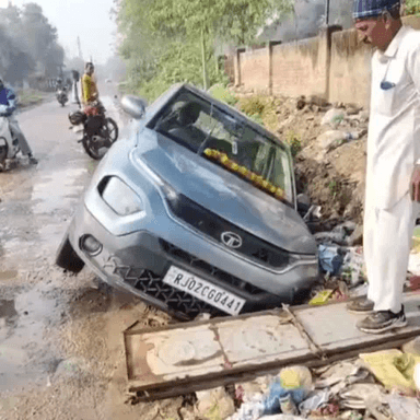 नीमराना: शाहजहांपुर में पलावा जा रहे कार सवार की कार बाइक सवार को बचाने के चक्कर में पानी के गड्ढे में गिरी, बड़ा हादसा टला