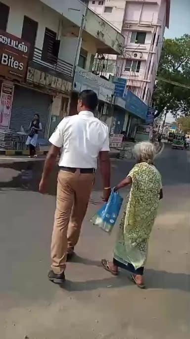 நாகர்கோவில் அருகே ரோட்டை கடந்து செல்ல முடியாமல் தவித்த பாட்டி ஒருவரை அப்பகுதியில் உள்ள போக்குவரத்து காவலர் சாலையை கடத்தி விடும் காட்சி