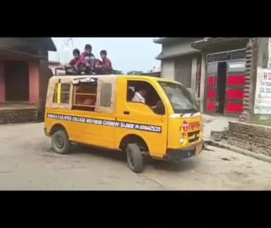 अफजलगढ़ क्षेत्र में एक निजी स्कूल बैन की छत पर बैठे स्कूल के बच्चे