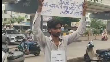 देवास: जिला न्यायालय के सामने पोस्टर लेकर खड़ा युवक, बना चर्चा का विषय