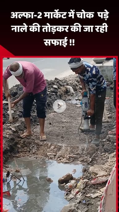 गौतम बुद्ध नगर: अल्फा-2 मार्केट में चोक पड़े नाले की सफाई के लिए तोड़कर की जा रही कार्रवाई